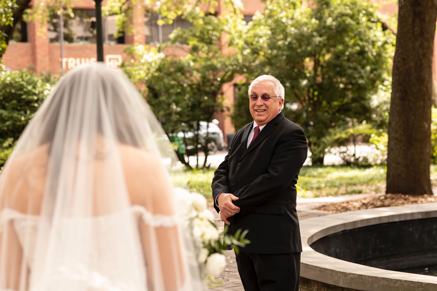 A bride and officiant stand together outdoors during a first look moment at an autumn wedding ceremony.