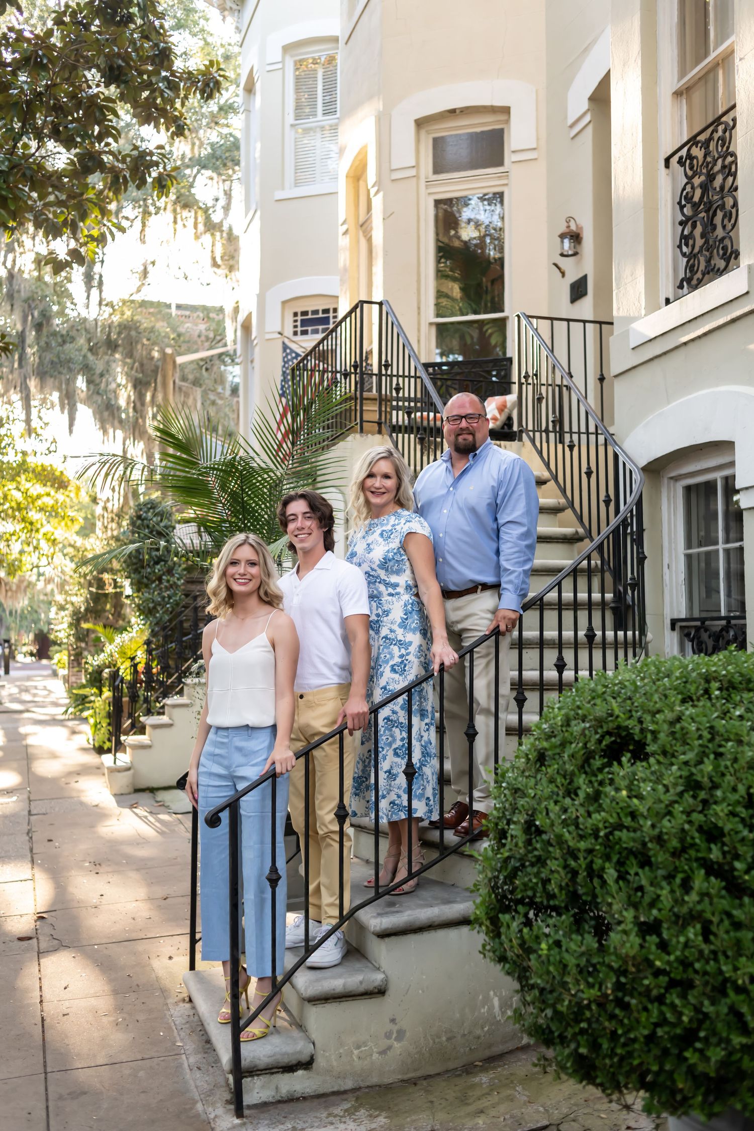 Southern style home with wrought iron railings and palm trees along a historic street.