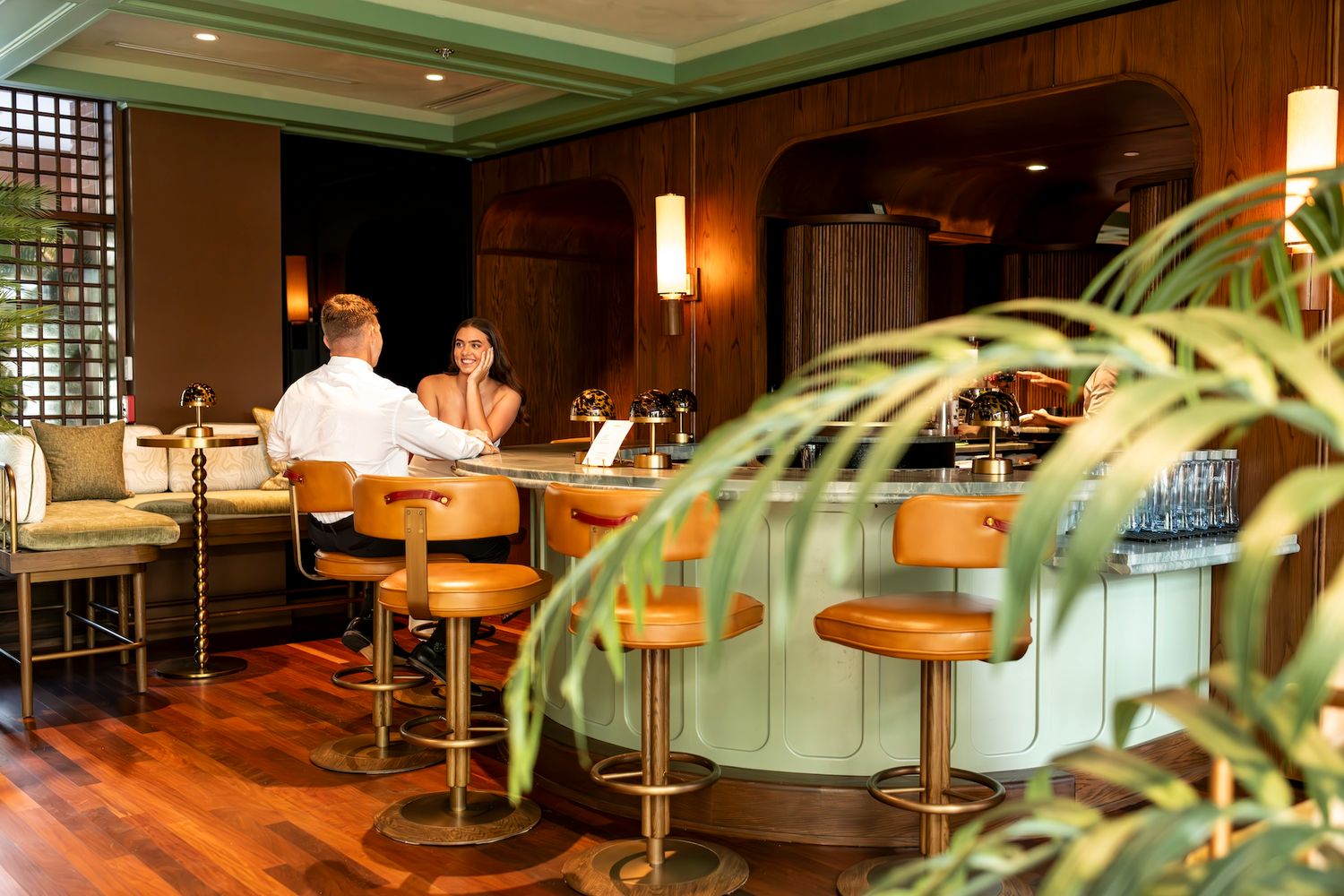 Modern restaurant interior with wooden walls, pendant lighting, and bar seating creates an intimate dining atmosphere.