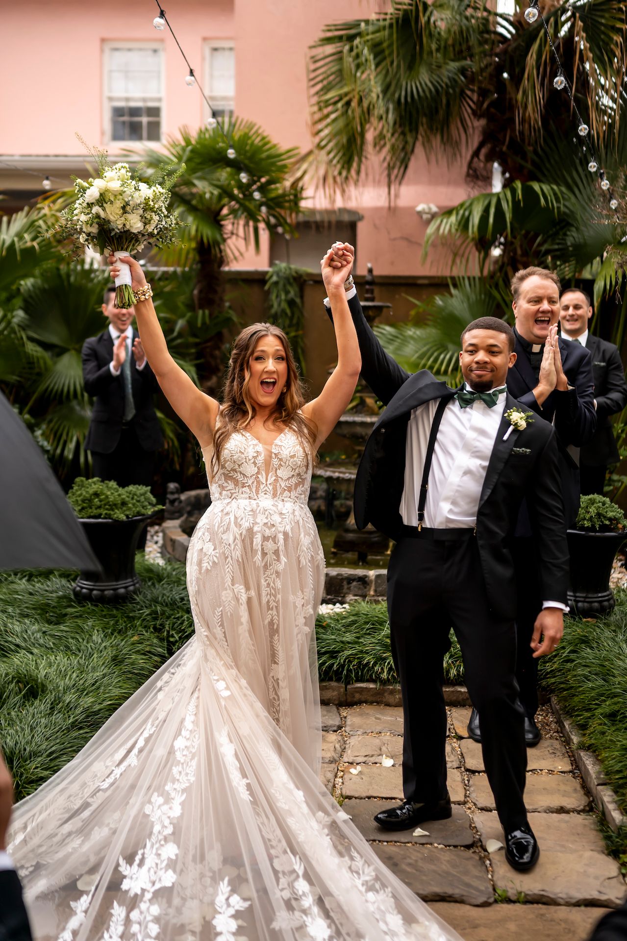 A newlywed couple celebrates joyfully during a series of candid wedding photos in front of pink stucco and palm trees.