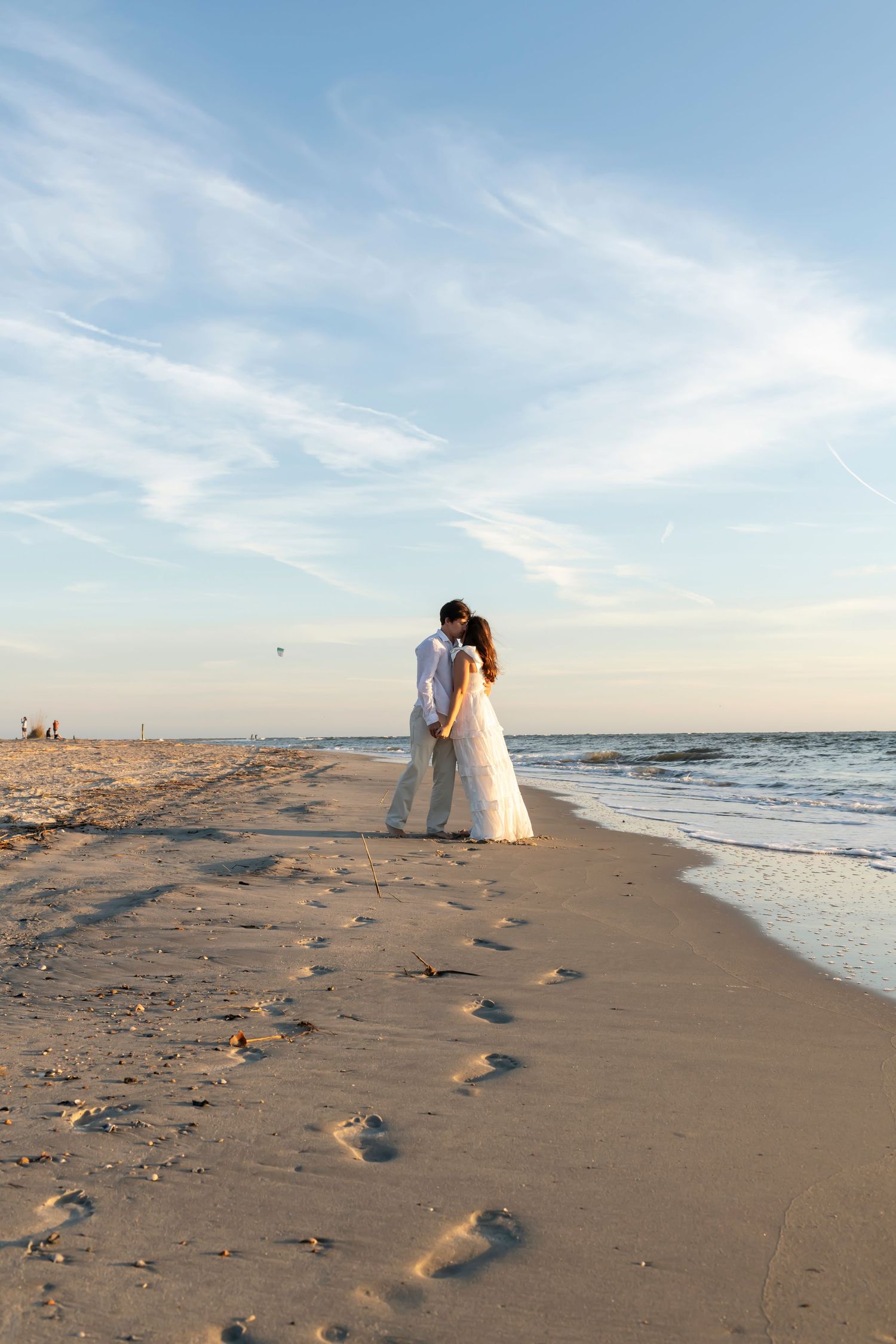 Five sequential photos of a sunset beach wedding scene showing footprints in the sand leading to a couple by the ocean.