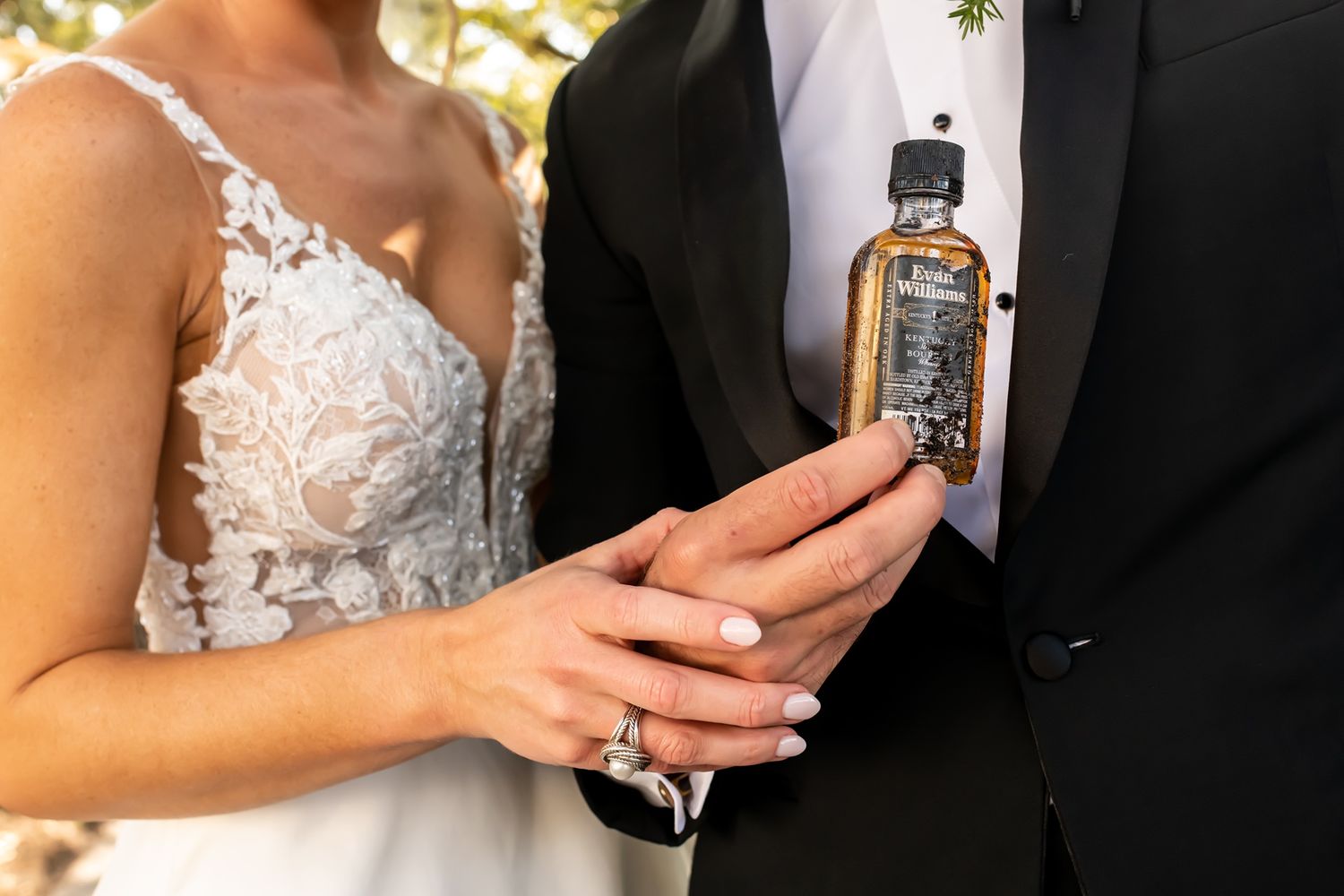 Elegant wedding attire shown in formal photos with a bottle of Jack Daniels whiskey and lace details.