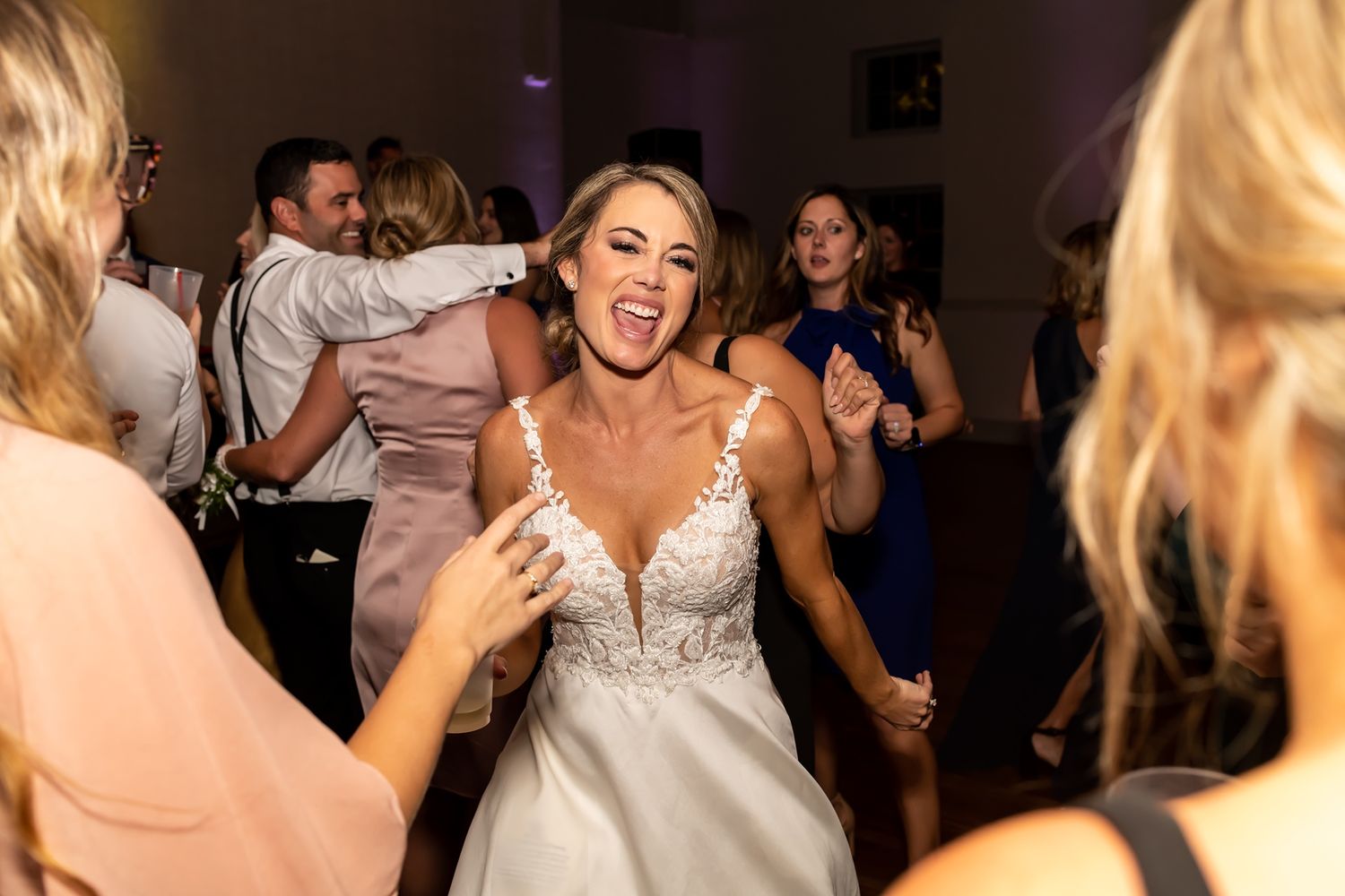A crowd of people celebrating and dancing energetically at a lively party event.