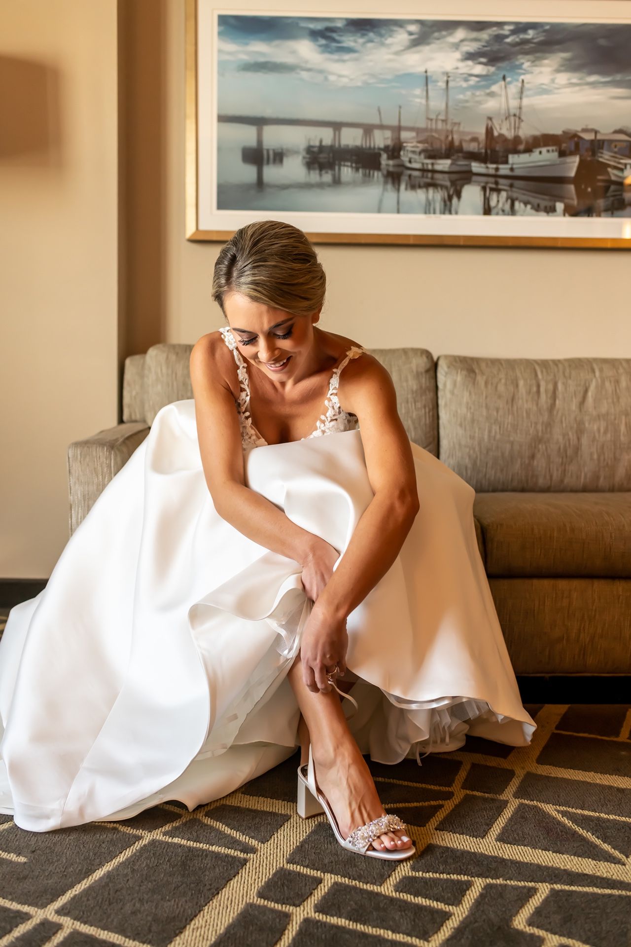 Wedding detail photo showing elegant bridal shoes on a geometric patterned carpet in soft beige tones.