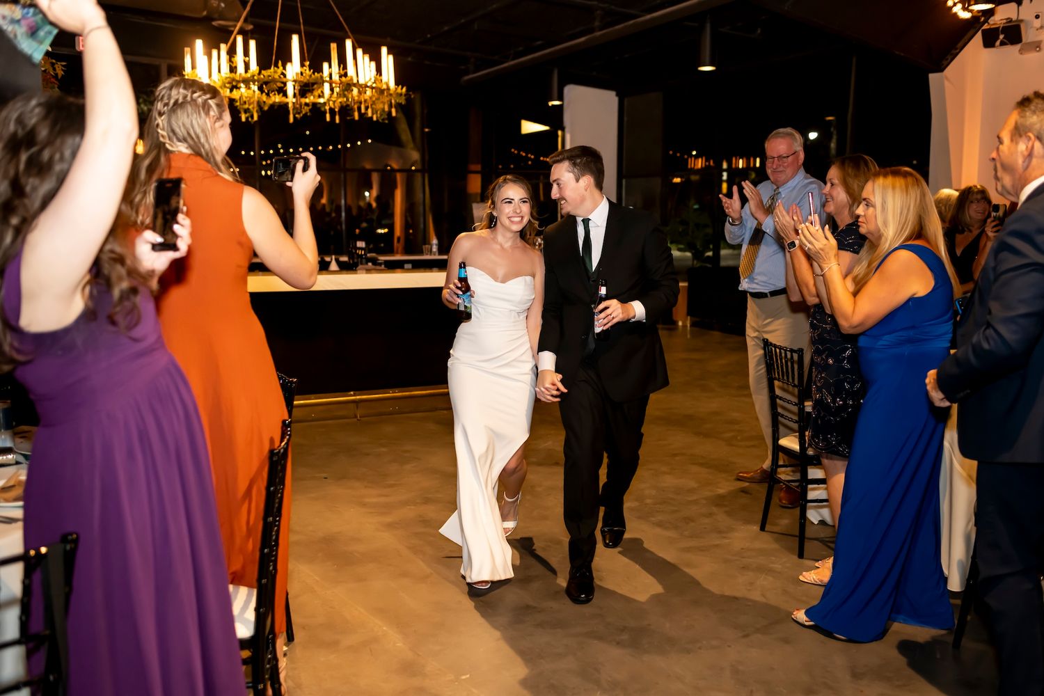 Guests celebrate on the dance floor at a formal evening wedding reception with elegant lighting and decor.