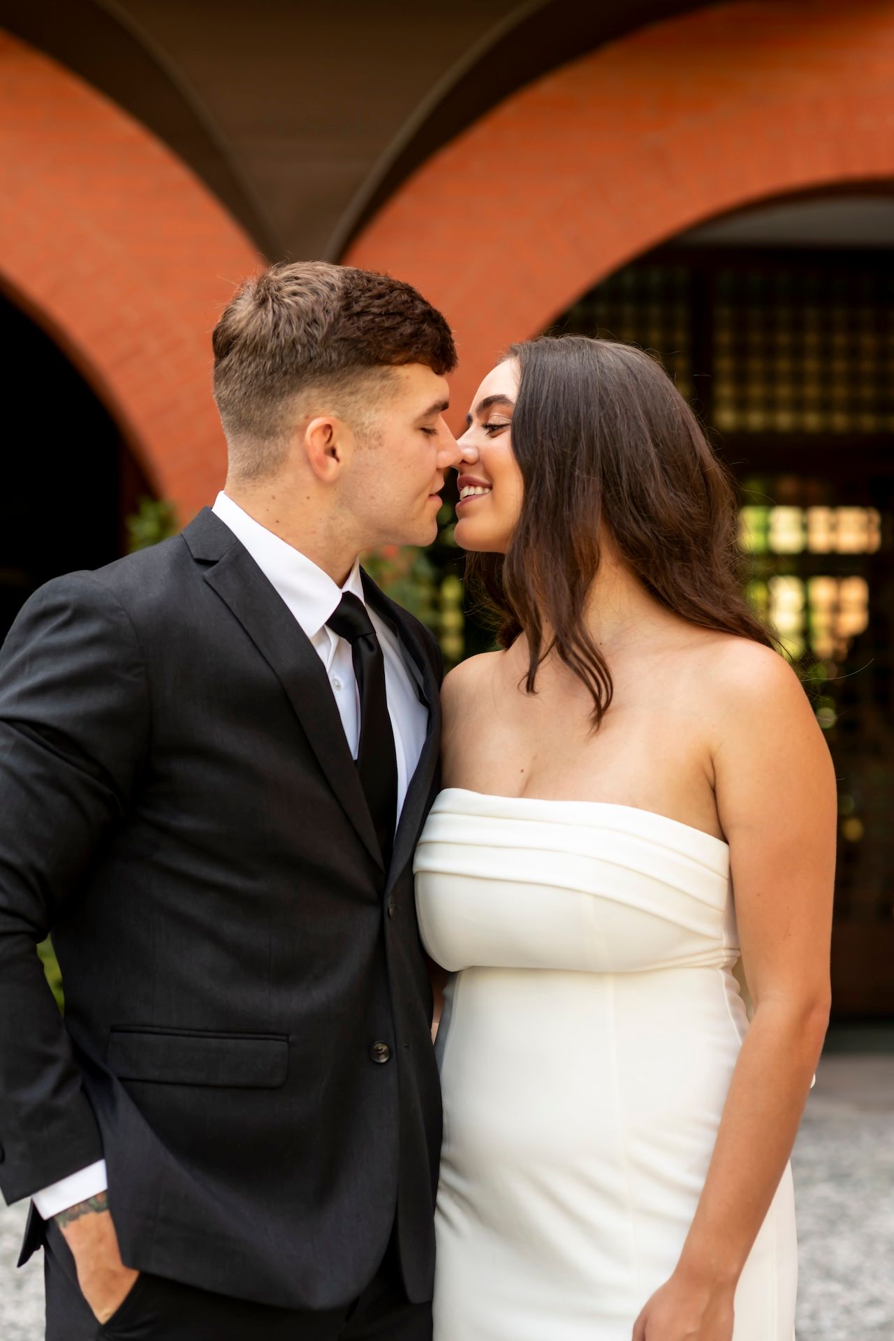 A romantic series of wedding photos showing a couple in formal attire sharing tender kisses at their ceremony.