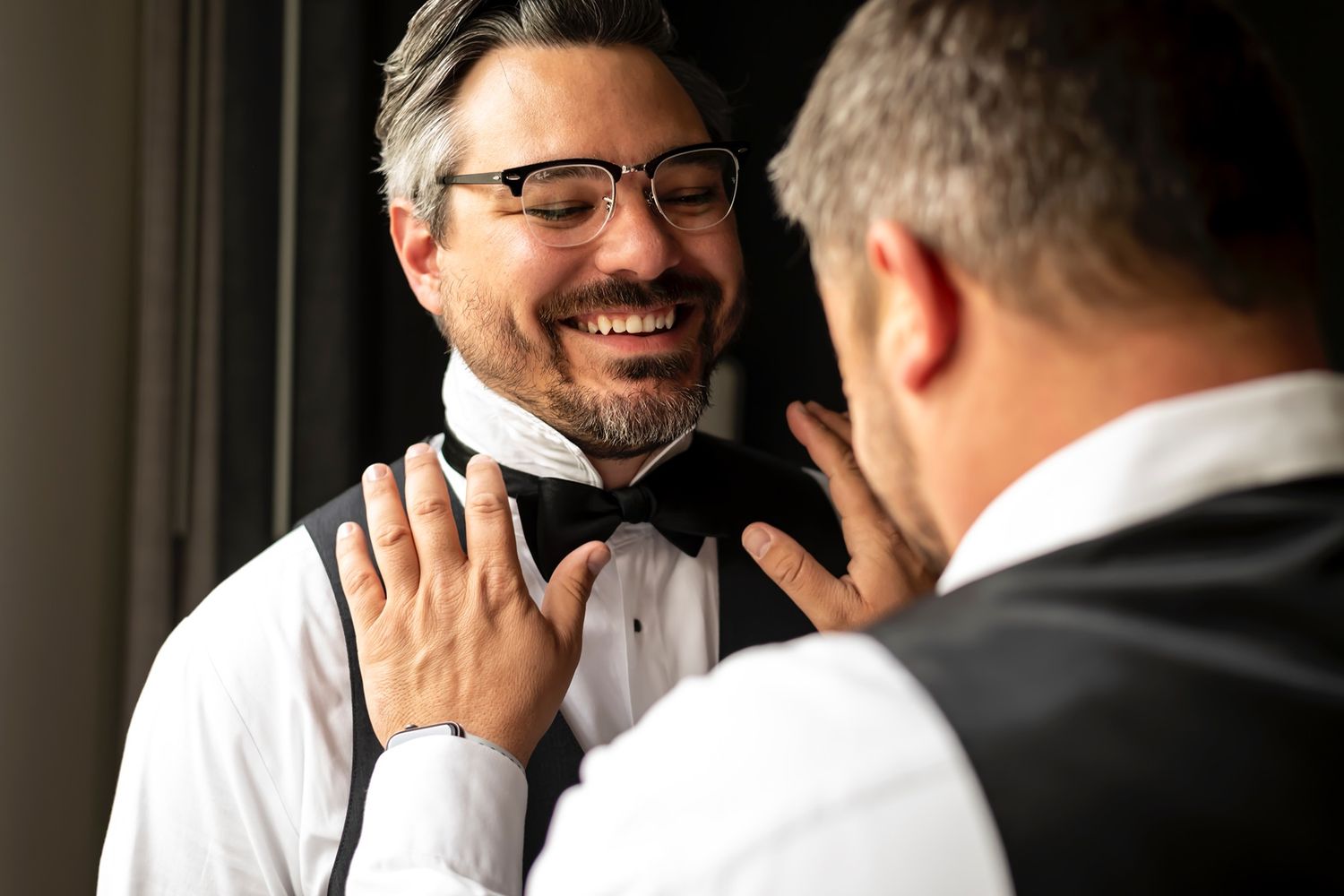 Two professionals engaging in an animated business conversation while wearing white shirts in an office setting.