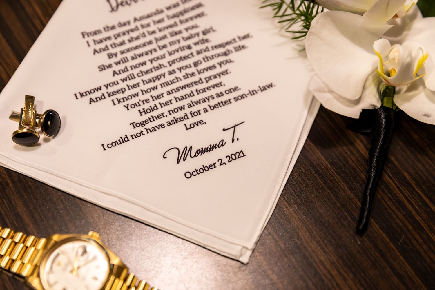 Handwritten wedding vows on white paper cards with delicate floral accents rest on a dark wooden surface.