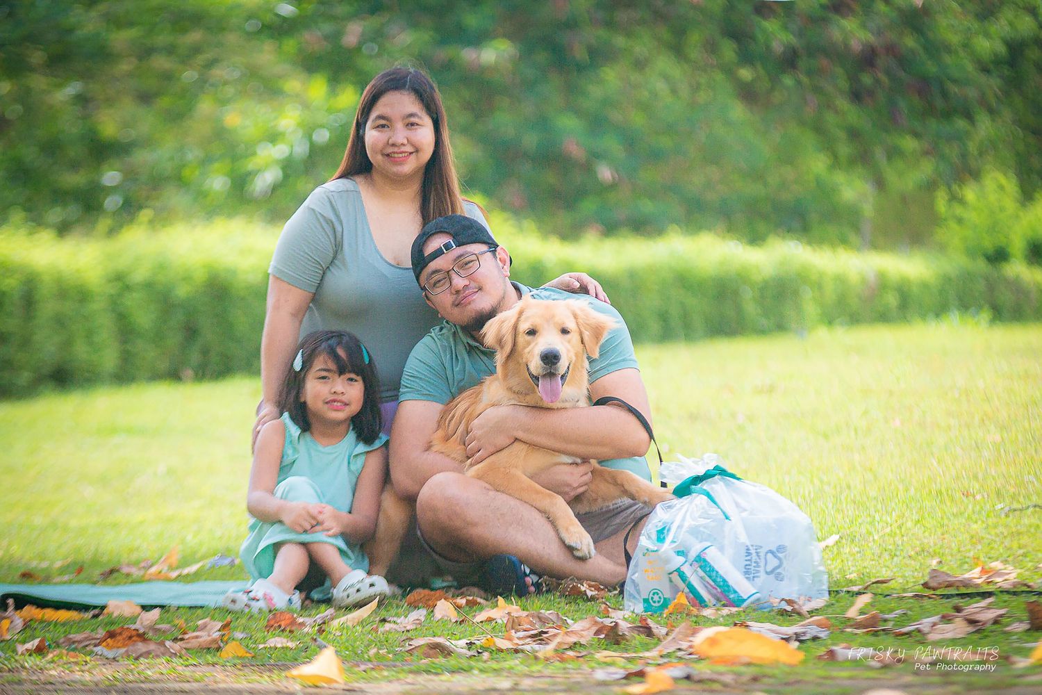 outdoor portrait of a family with their golden retriever dog
