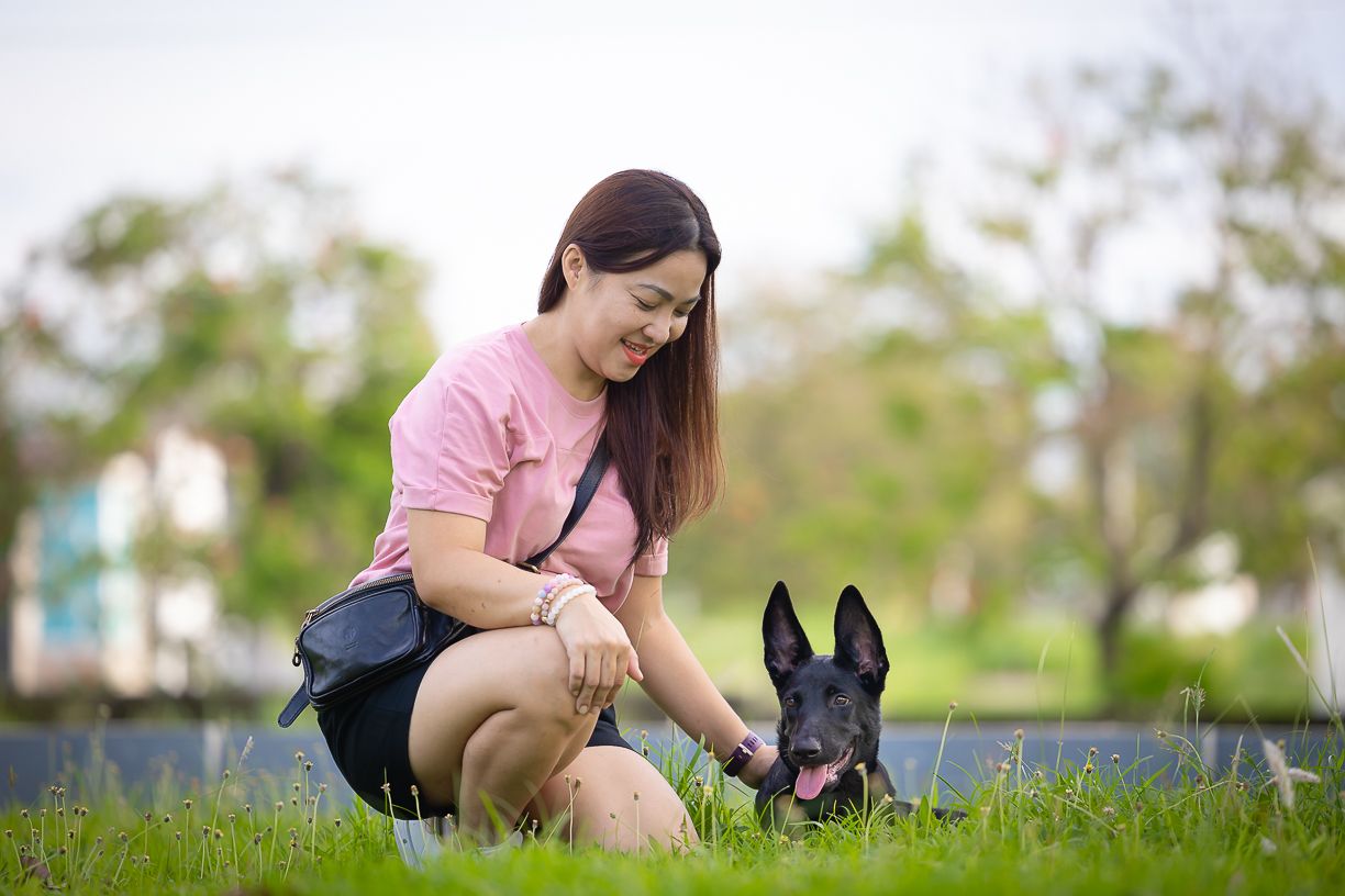 lady and her black dog enjoying their time at the park