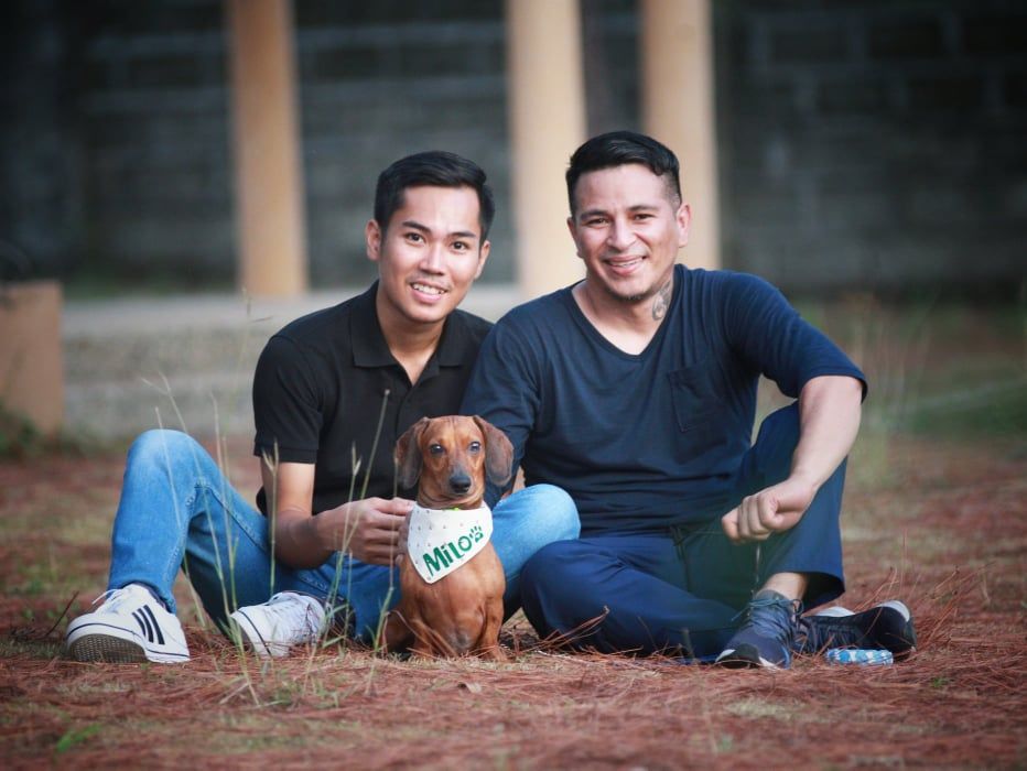 outdoor portrait of a gay couple with their brown dog