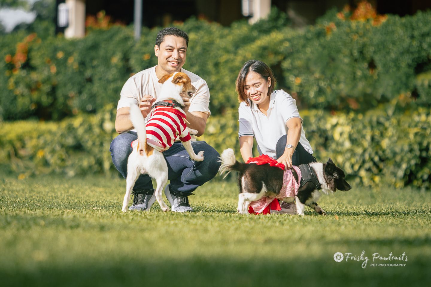 human siblings playing with their dogs at the garden