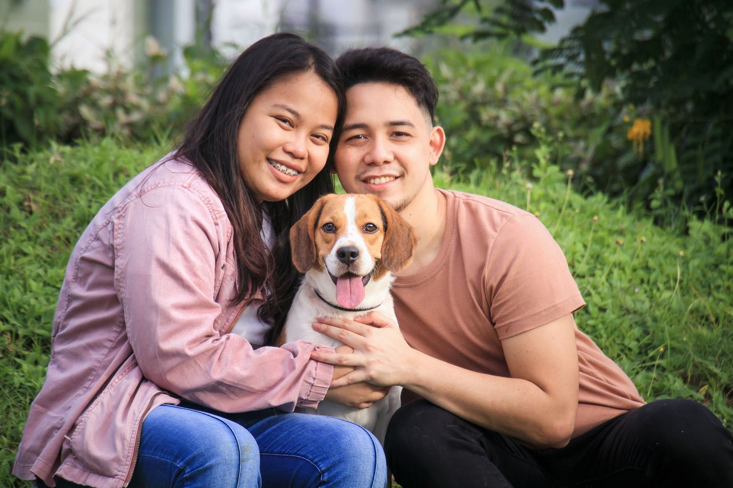 outdoor portrait of a human couple with their beagle