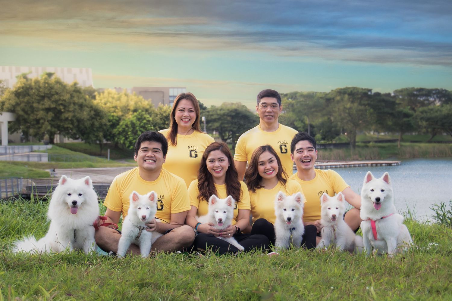 outdoor portrait by the lake of a family with their dogs