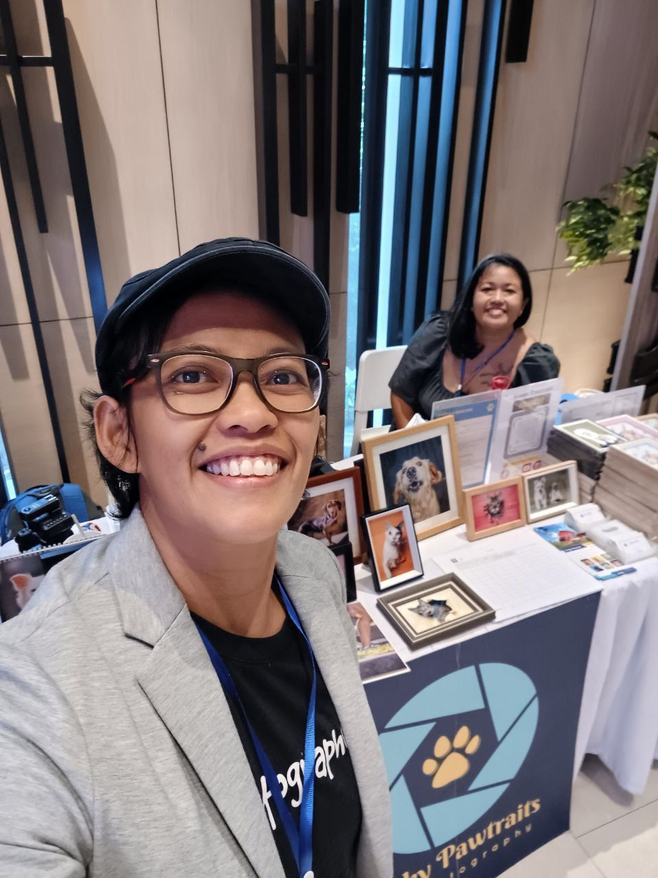 A vendor displays photo frames and merchandise at their booth during an indoor event or market.