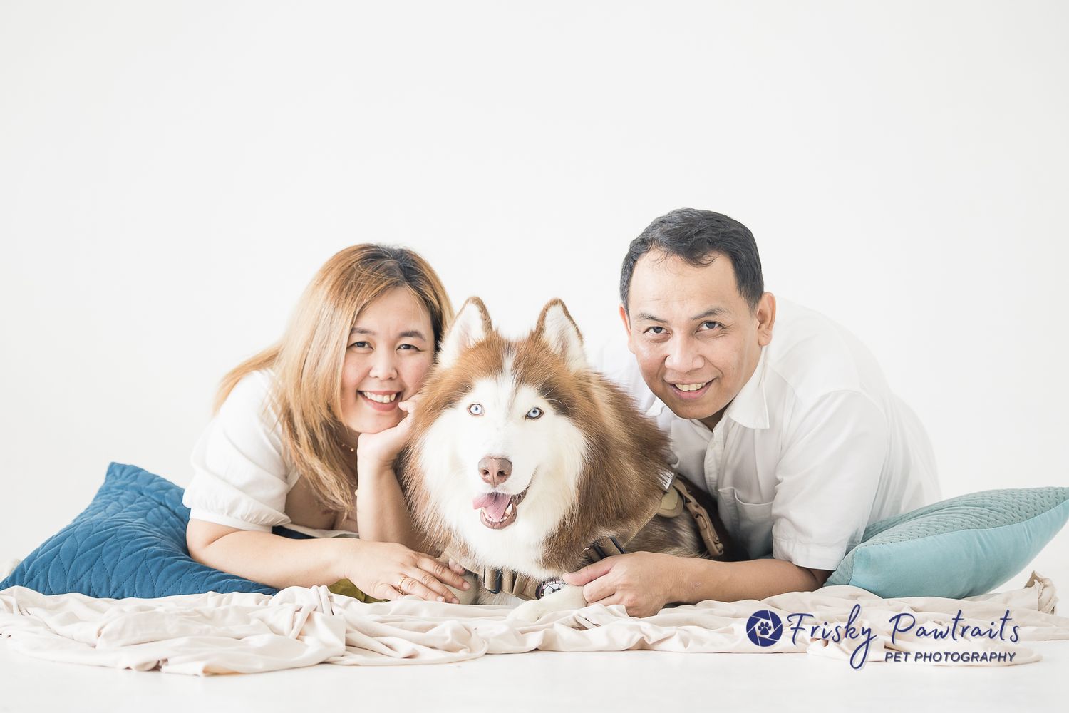 studio portrait of a human couple with their Siberian husky
