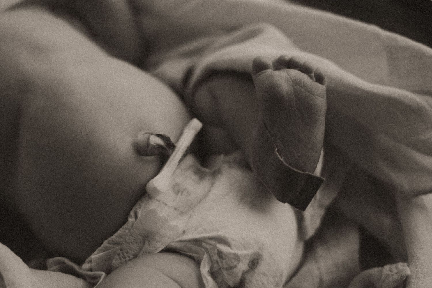 Intimate black and white photograph capturing newborn's delicate features during rest.