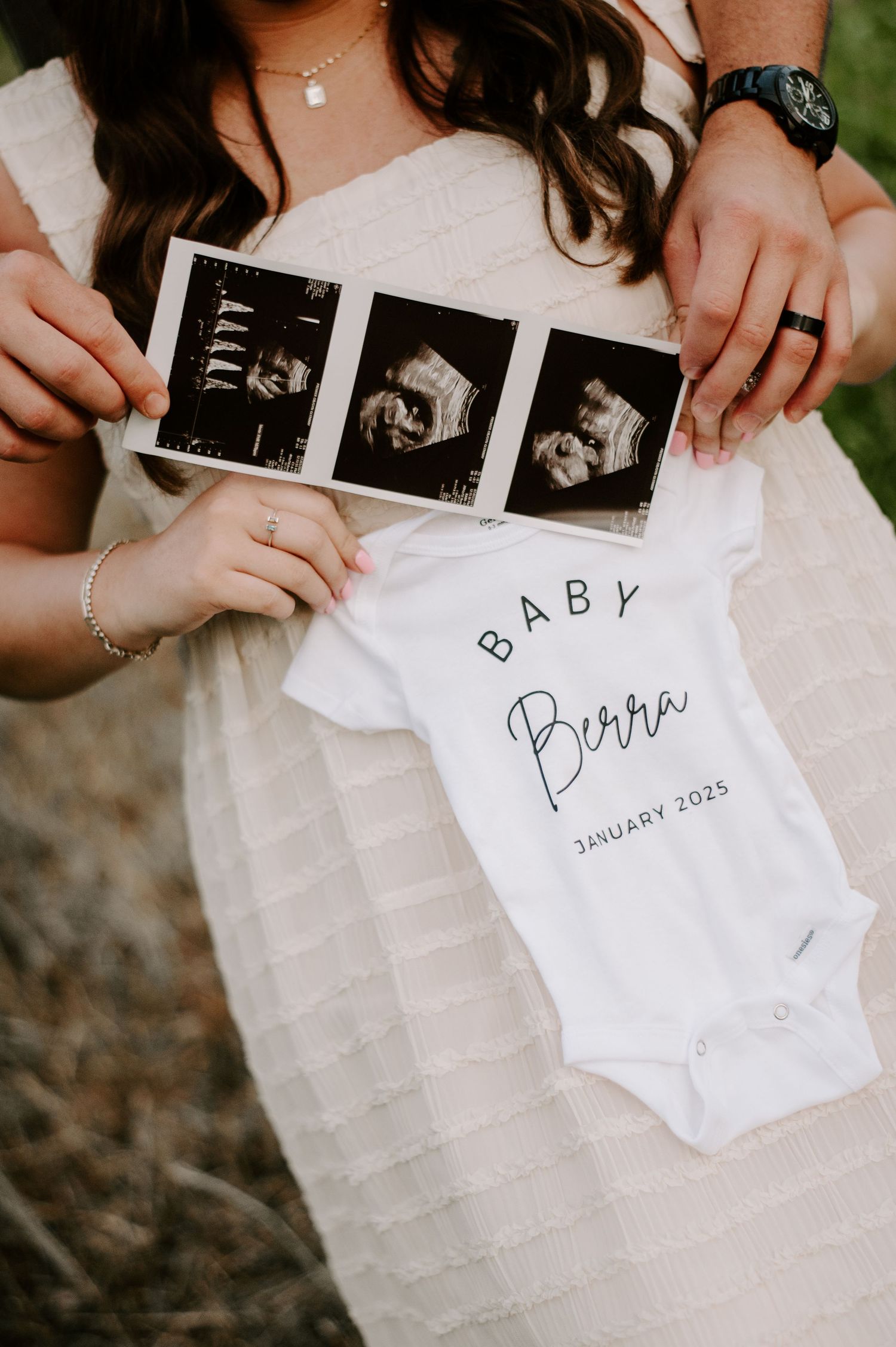 A pregnancy announcement featuring ultrasound photos and a white baby onesie with 'Baby' text and January 2025 due date.