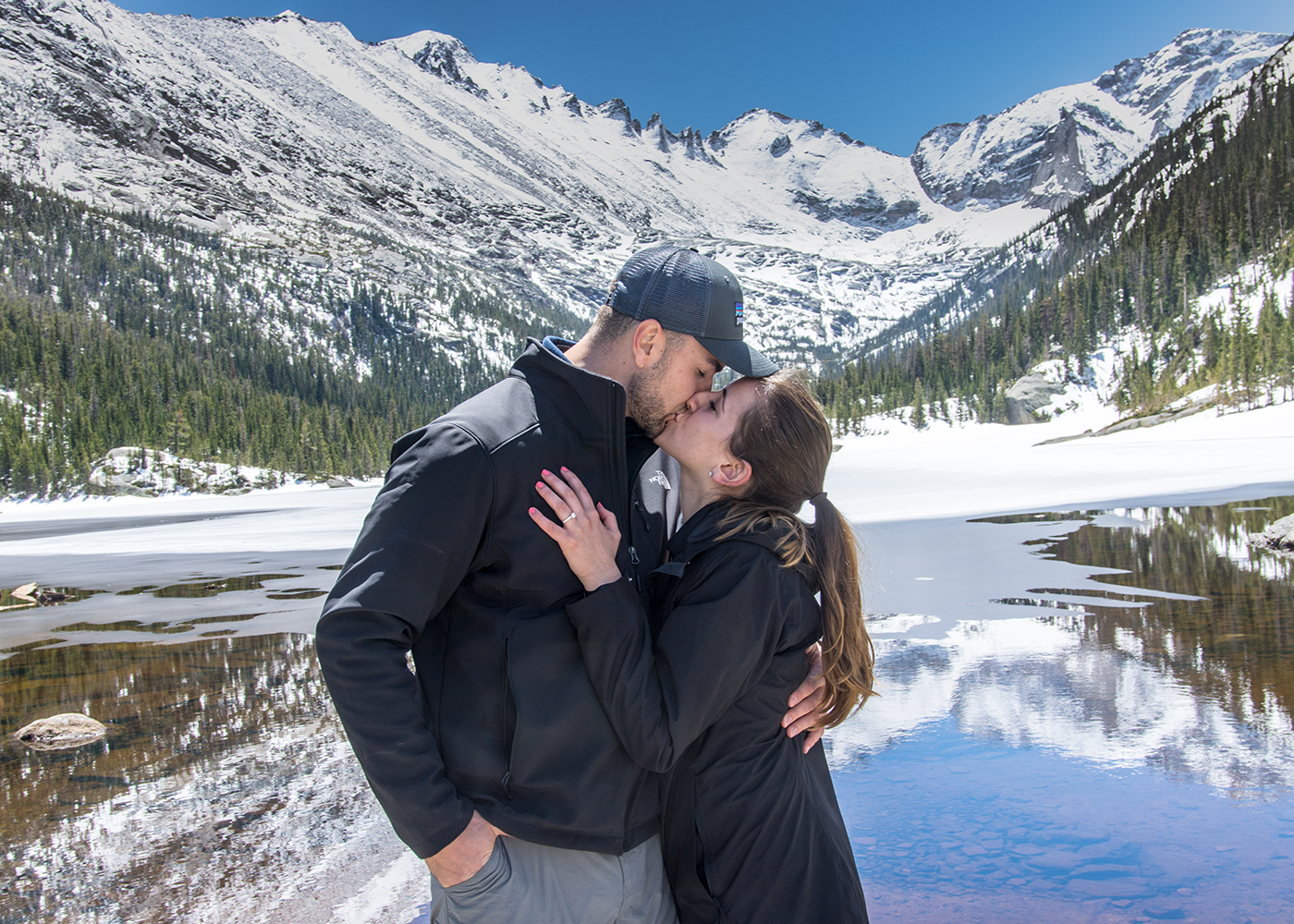 Couple kissing after a surprise marriage proposal photographed at Mills Lake in Rocky Mountain National Park