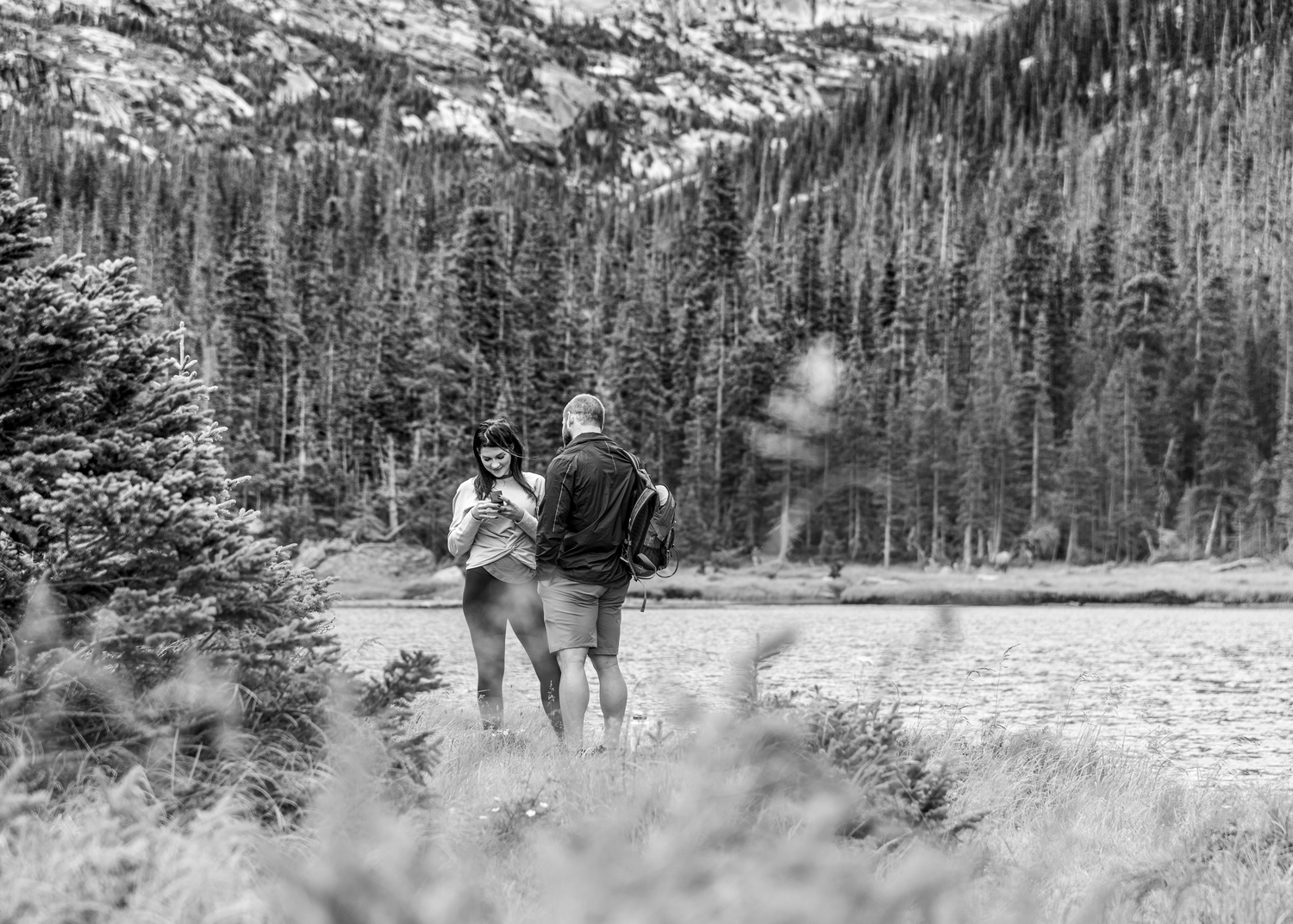 A woman admiring her brand new engagement ring she received after saying yes to his marriage proposal at Jewel Lake in RMNP