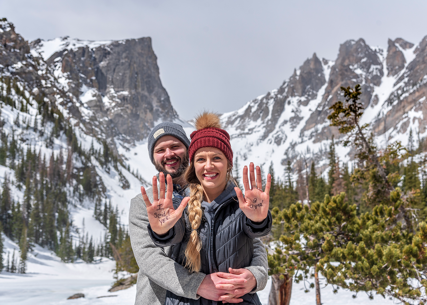 Two people very excited to celebrate their marriage proposal at Dream Lake in Rocky Mountain National Park