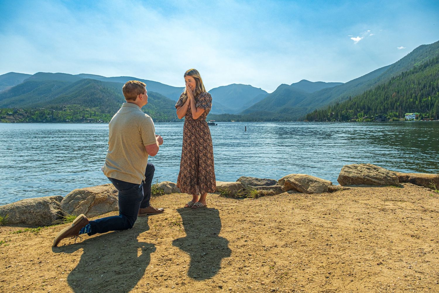 Surprise marriage proposal near Grand Lake, Colorado captured as man kneels during emotional moment.