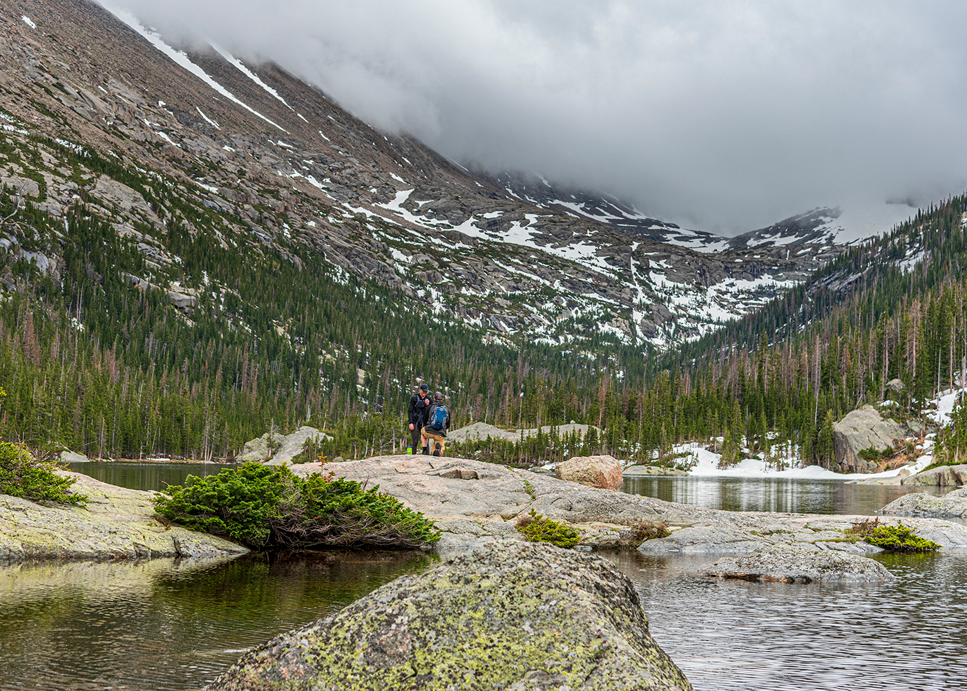 Man down on one knee proposing marriage at Mills Lake inside RMNP
