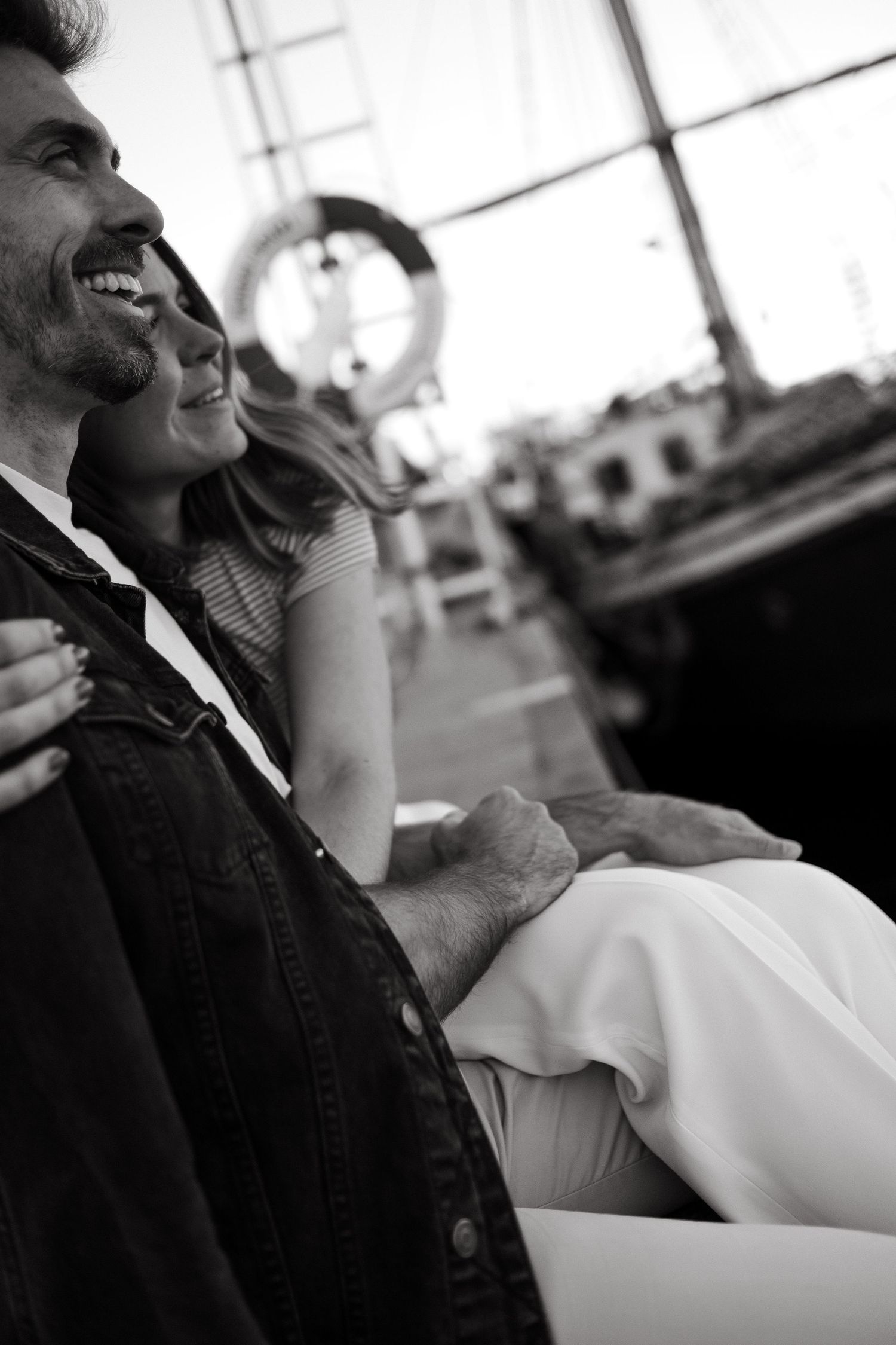 a woman hugging her boyfriend in a harbor looking at a view during vacation photoshoot in Stockholm