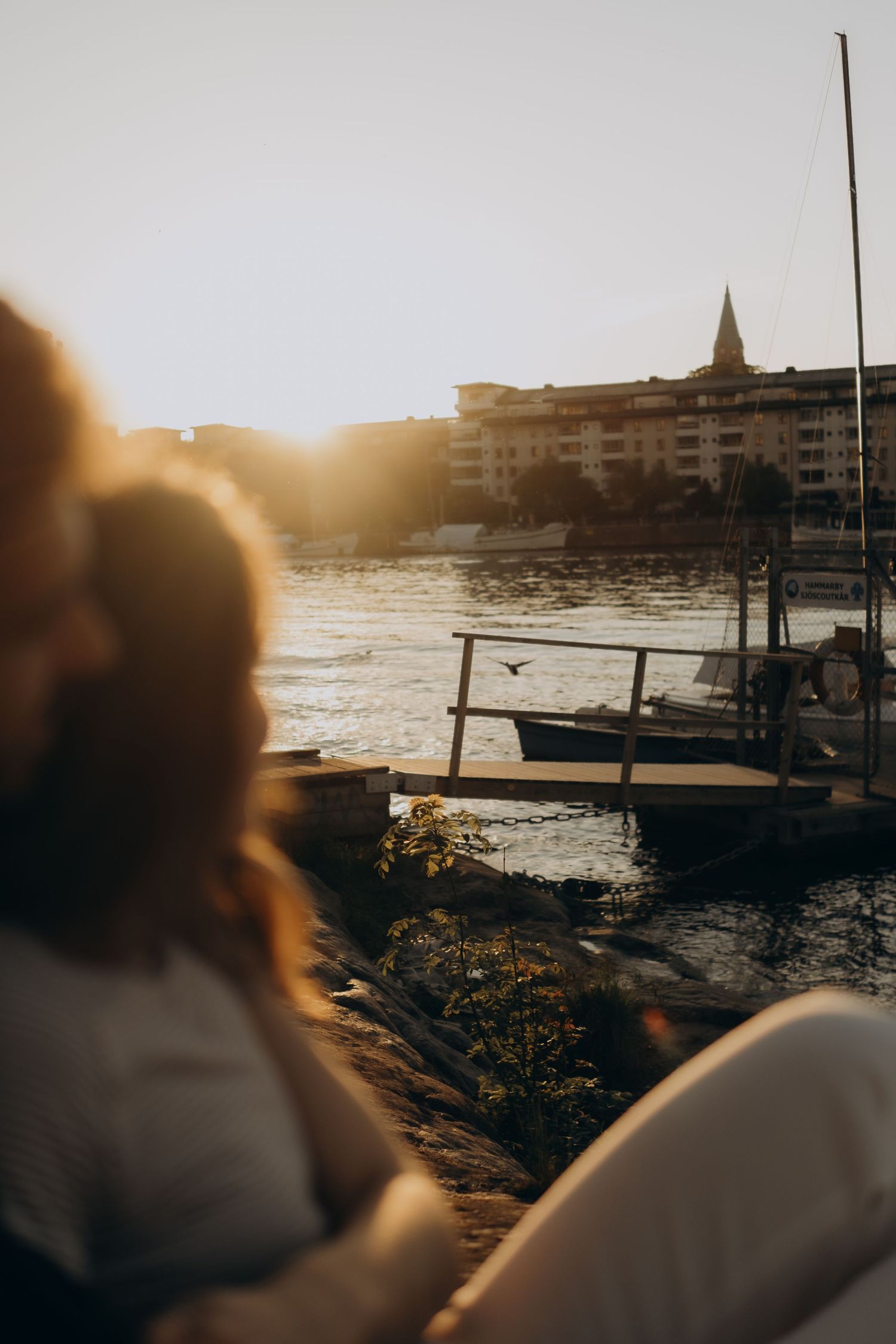 couple looking at a view during sunset with boats and flying birds during a cinematic photoshoot in Stockholm