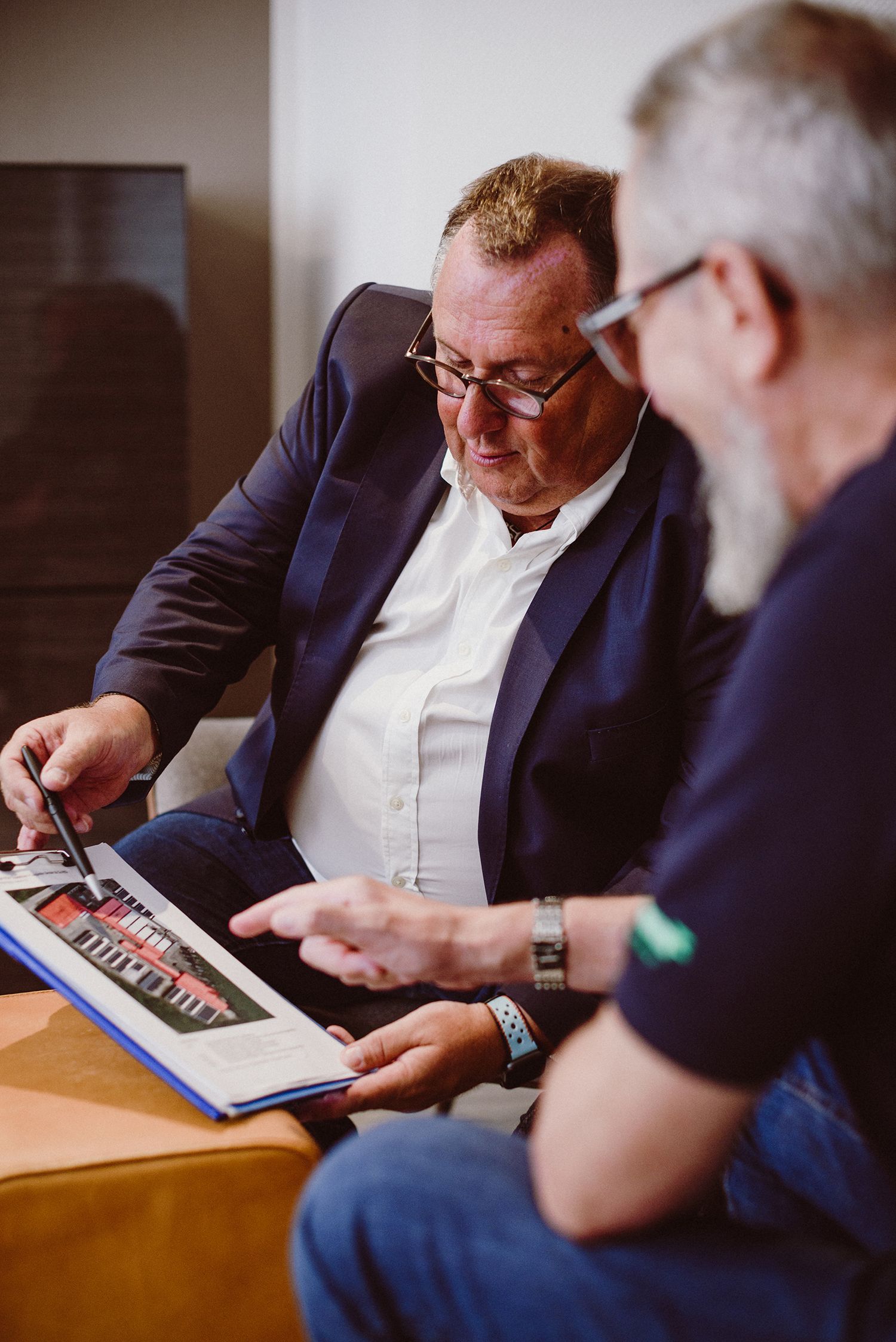Two business professionals reviewing documents together at office meeting.