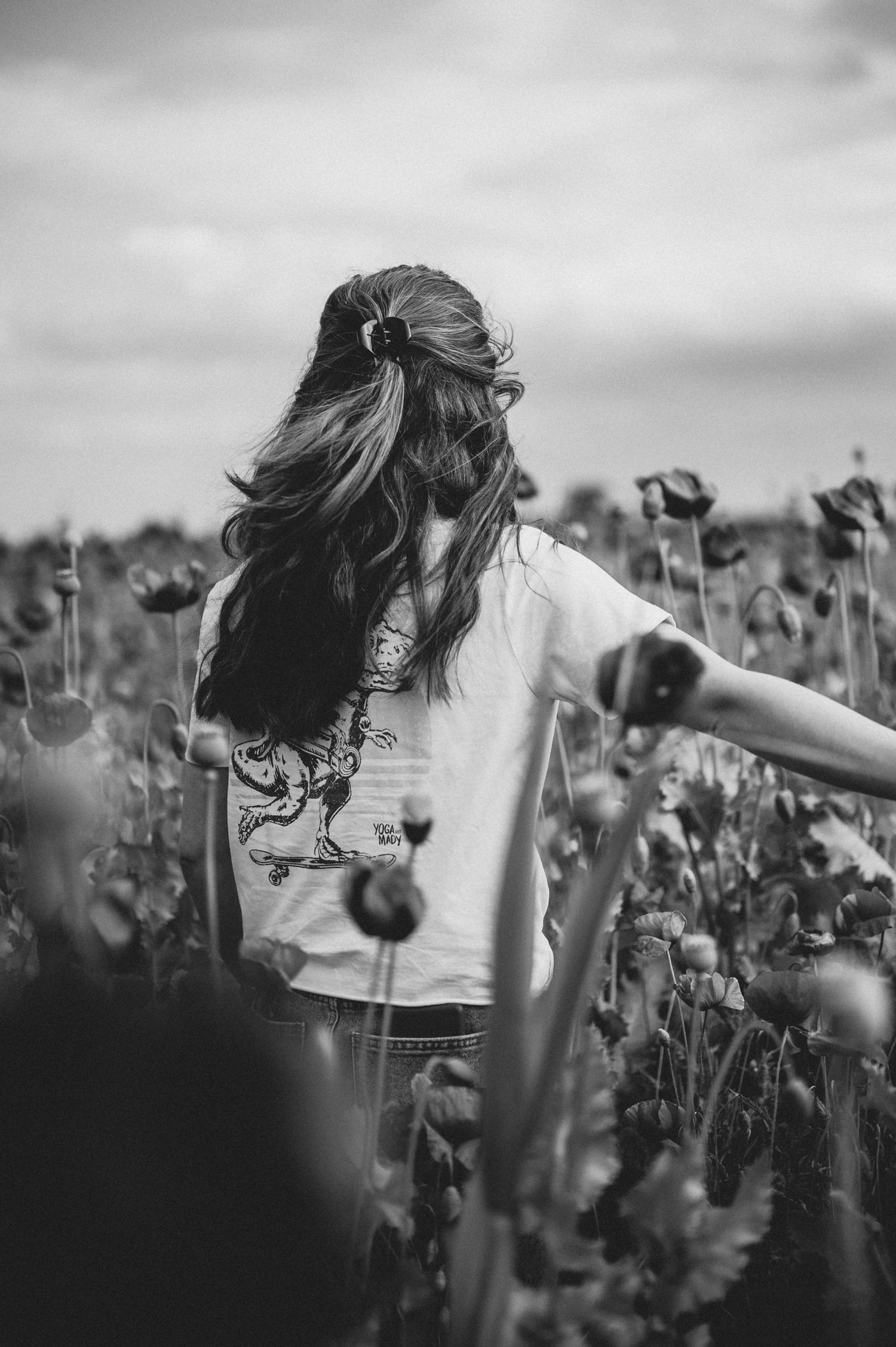 Black and white photo sequence showing someone twirling joyfully in a sunflower field wearing a white t-shirt.