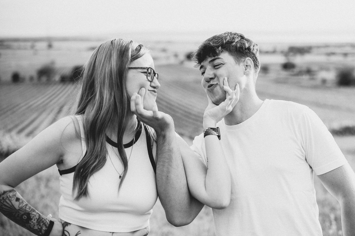 A black and white photo series showing romantic couple moments with intimate embraces and tender interactions in an outdoor setting.