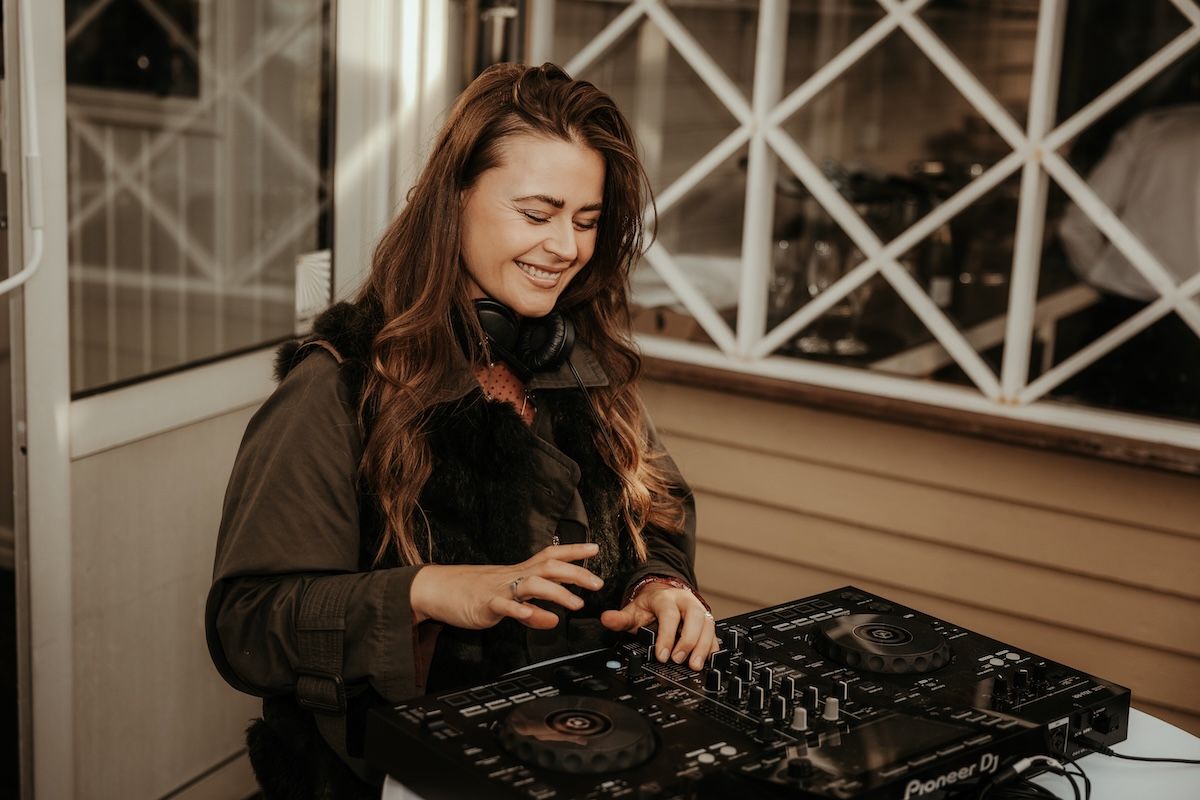 En DJ som spelar festlig musik under ett mingel under ett bröllop på terrassen av Särö Blomstermåla. Foto av Grevholm Photography