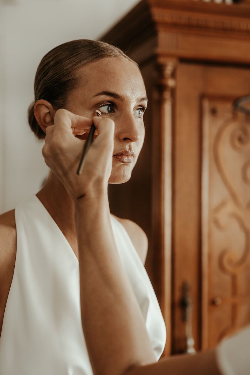 En MUA gör de sista detaljerna på en brud inför ett bröllop på västkusten. Foto av Grevholm Photography