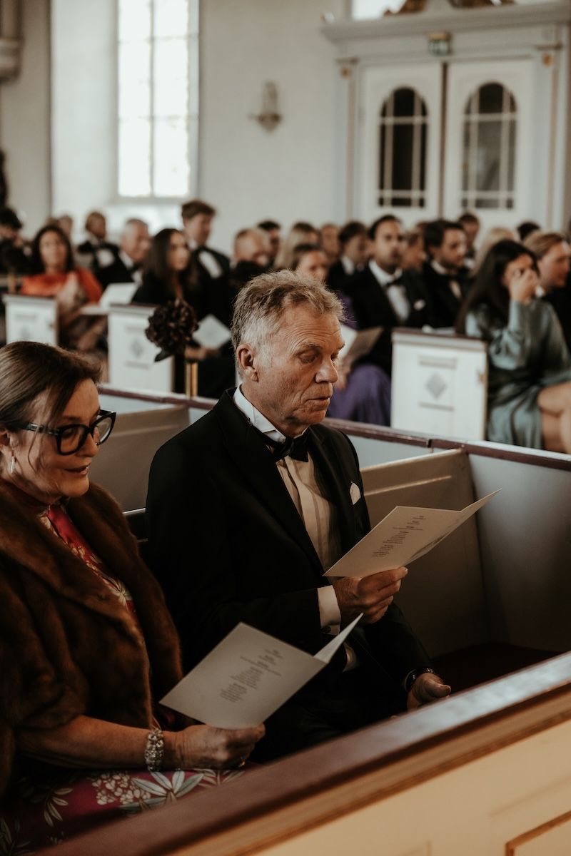 En bröllopsgäst sjunger med i en av låtarna under en vigselceremoni. Foto av Grevholm Photography