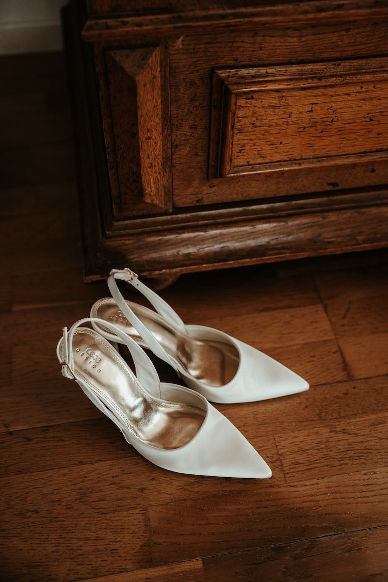 Närbild på vita eleganta brudskor. Foto av Grevholm Photography