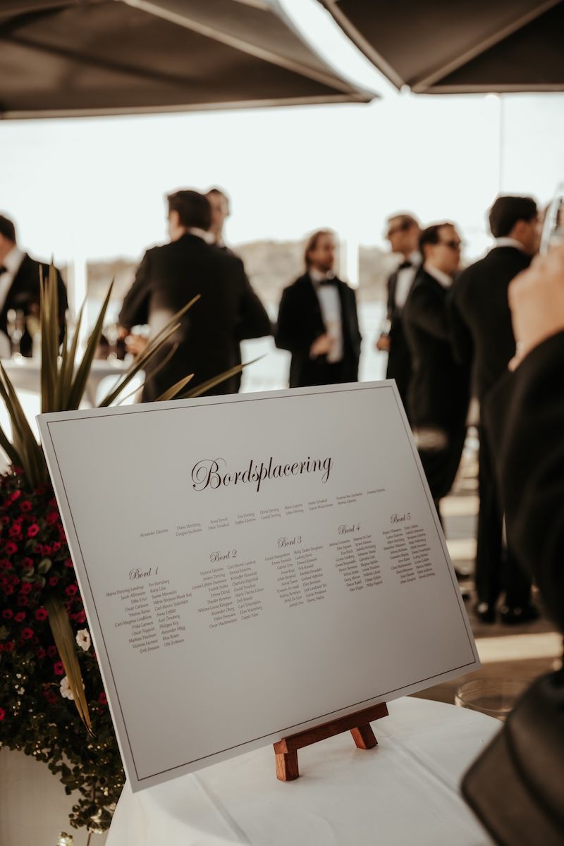 En elegant bordsplaceringsskylt på ett bröllop vid havet. Foto av Grevholm Photography