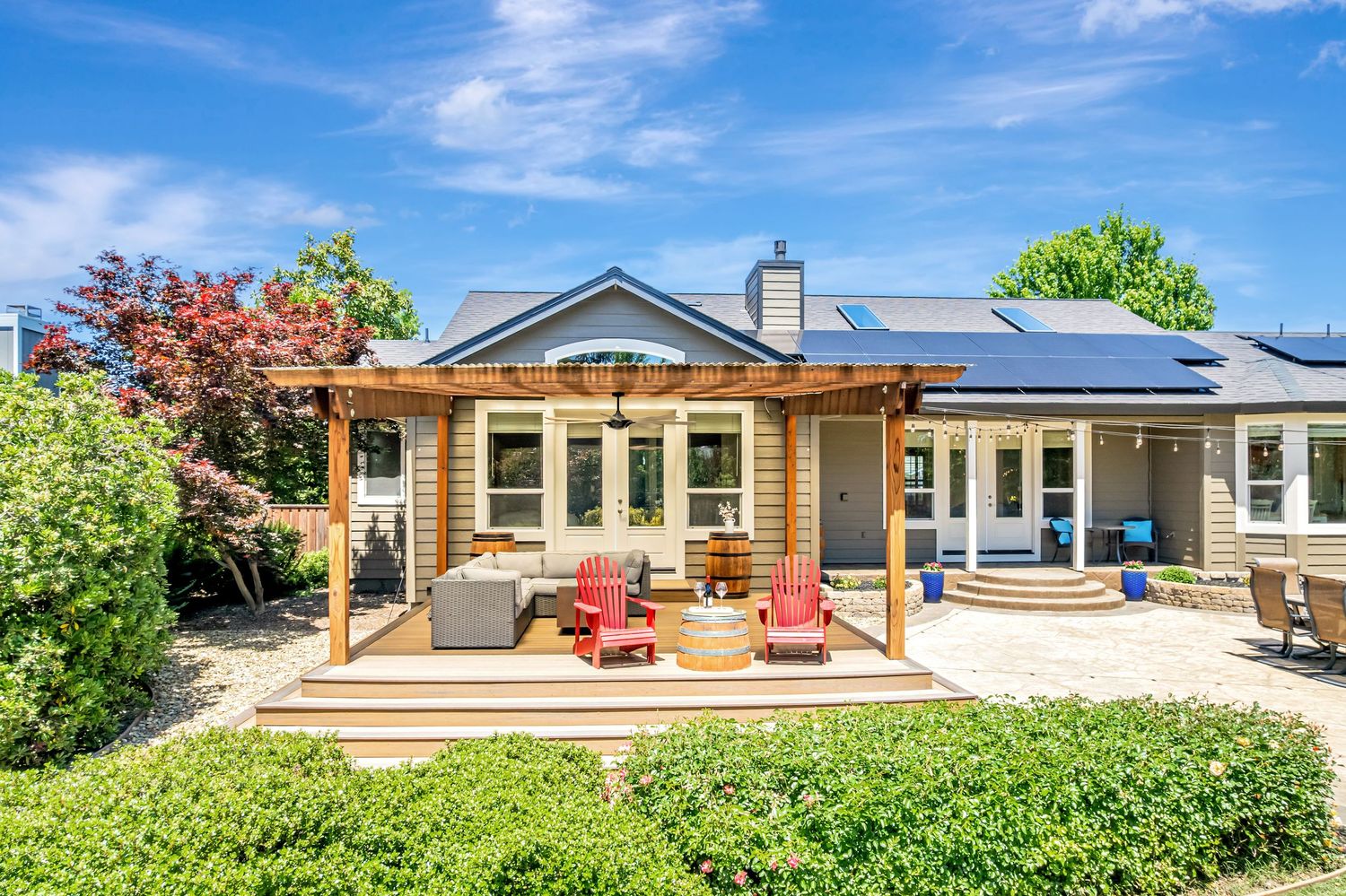 Craftsman style home exterior with covered porch and red outdoor seating area.