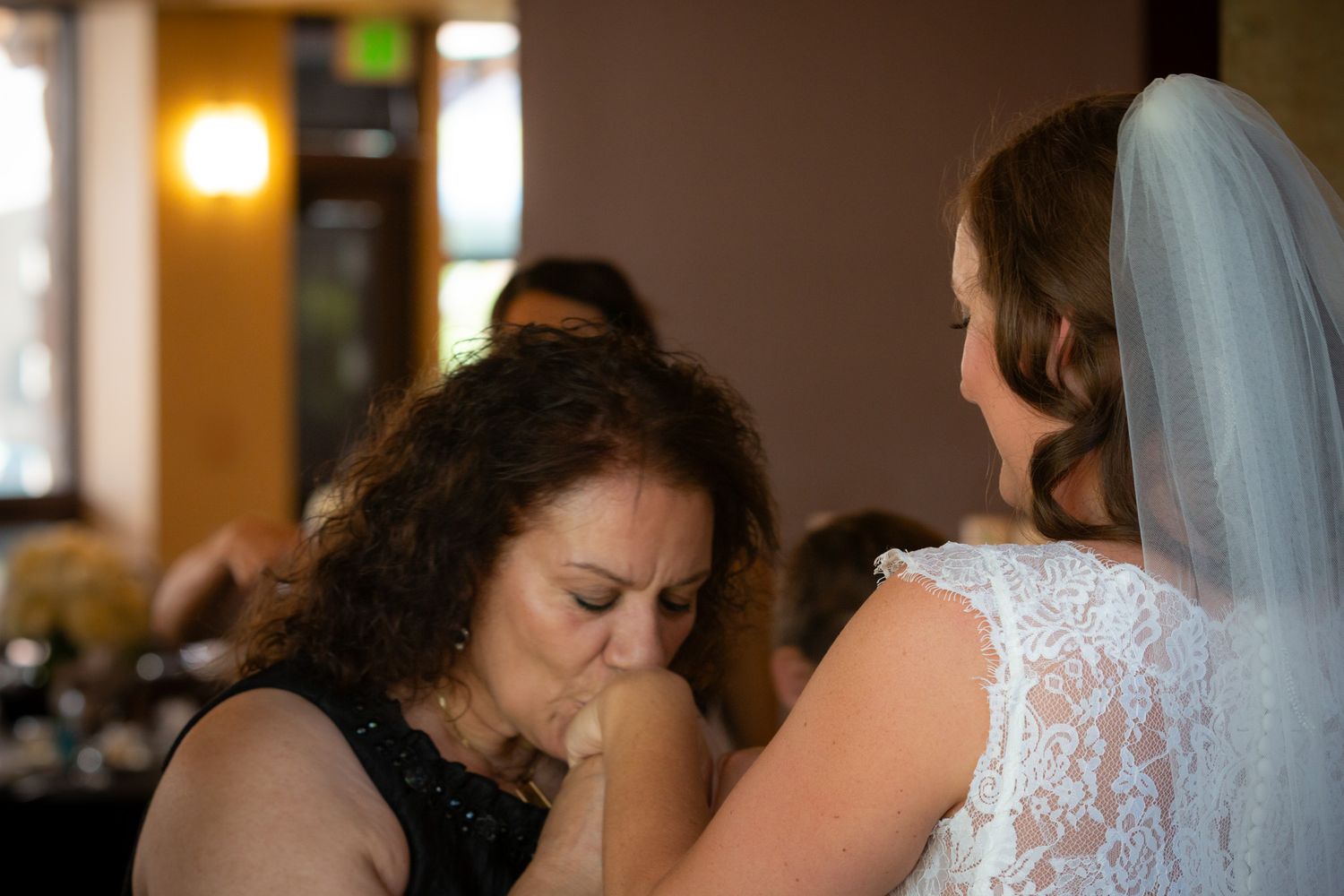 A touching moment between wedding attendees during the celebration.
