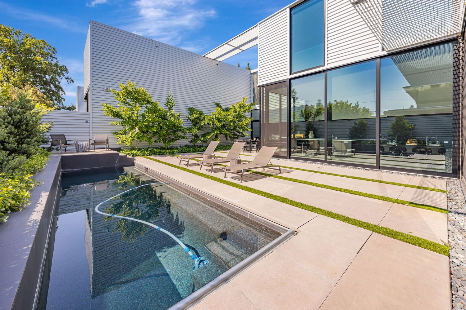 Sleek contemporary house with swimming pool and terraced concrete deck.