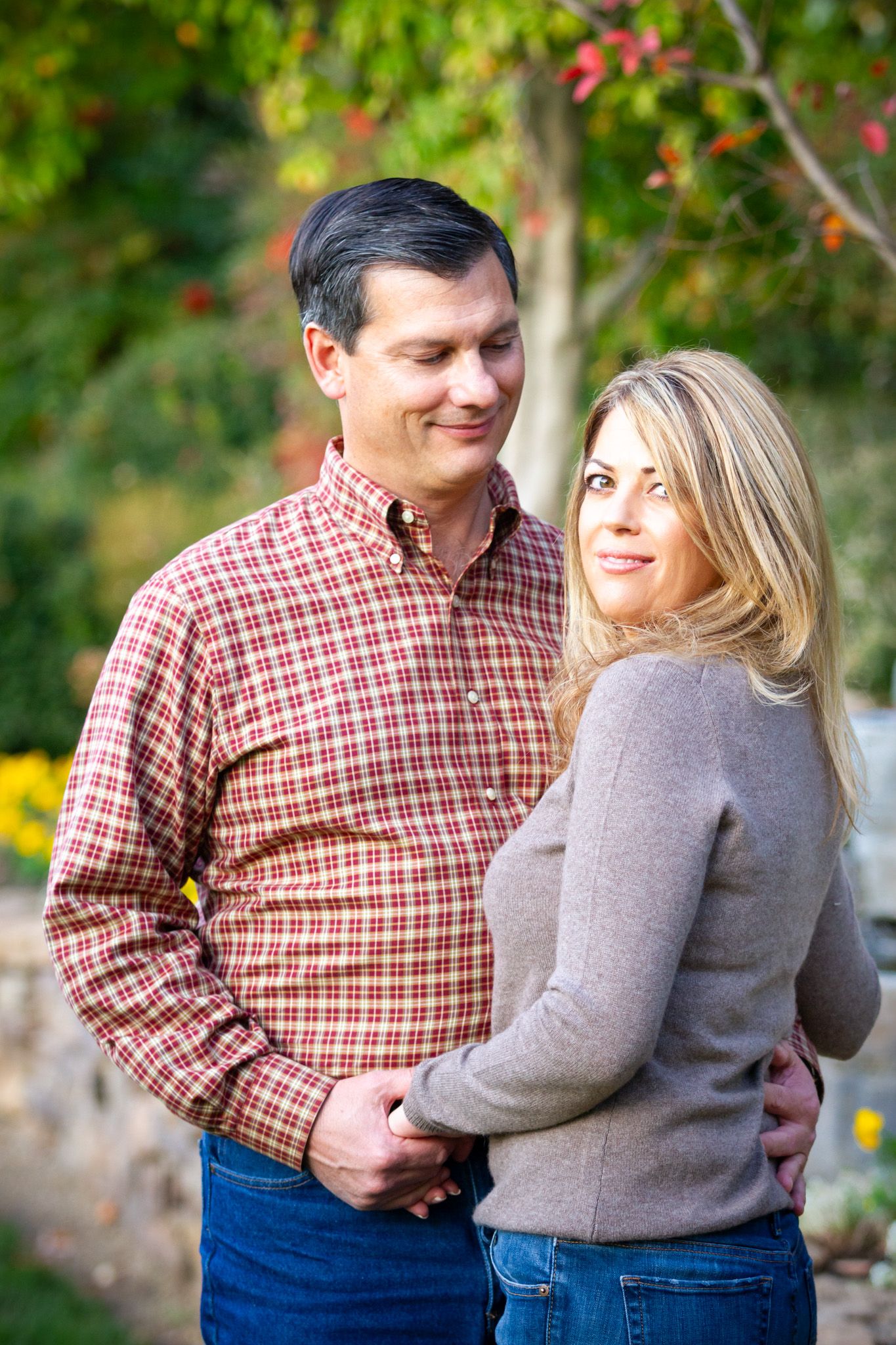 Outdoor engagement session featuring couple in casual plaid and sweater attire.