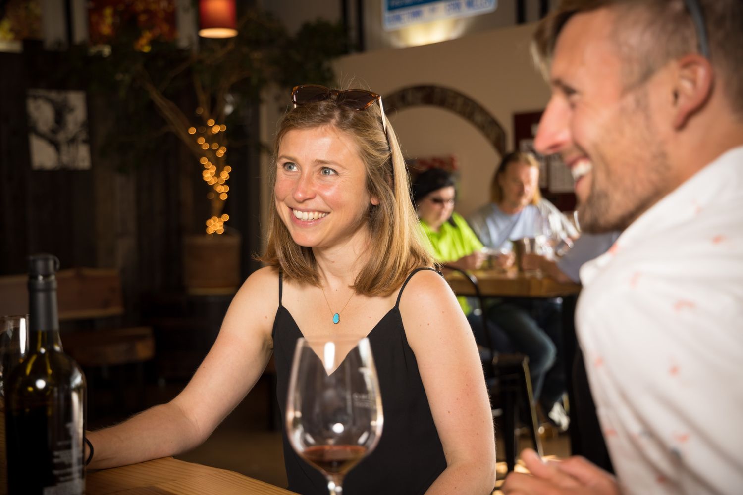 Casual dining scene with guests enjoying wine and conversation at a bar.