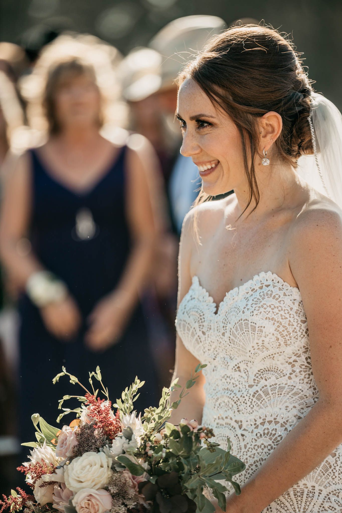 Beautiful lace wedding dress with delicate bouquet of pink and white flowers.