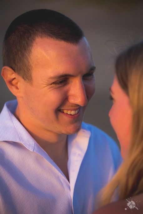 Close-up portrait of a smiling person lit with warm evening light.