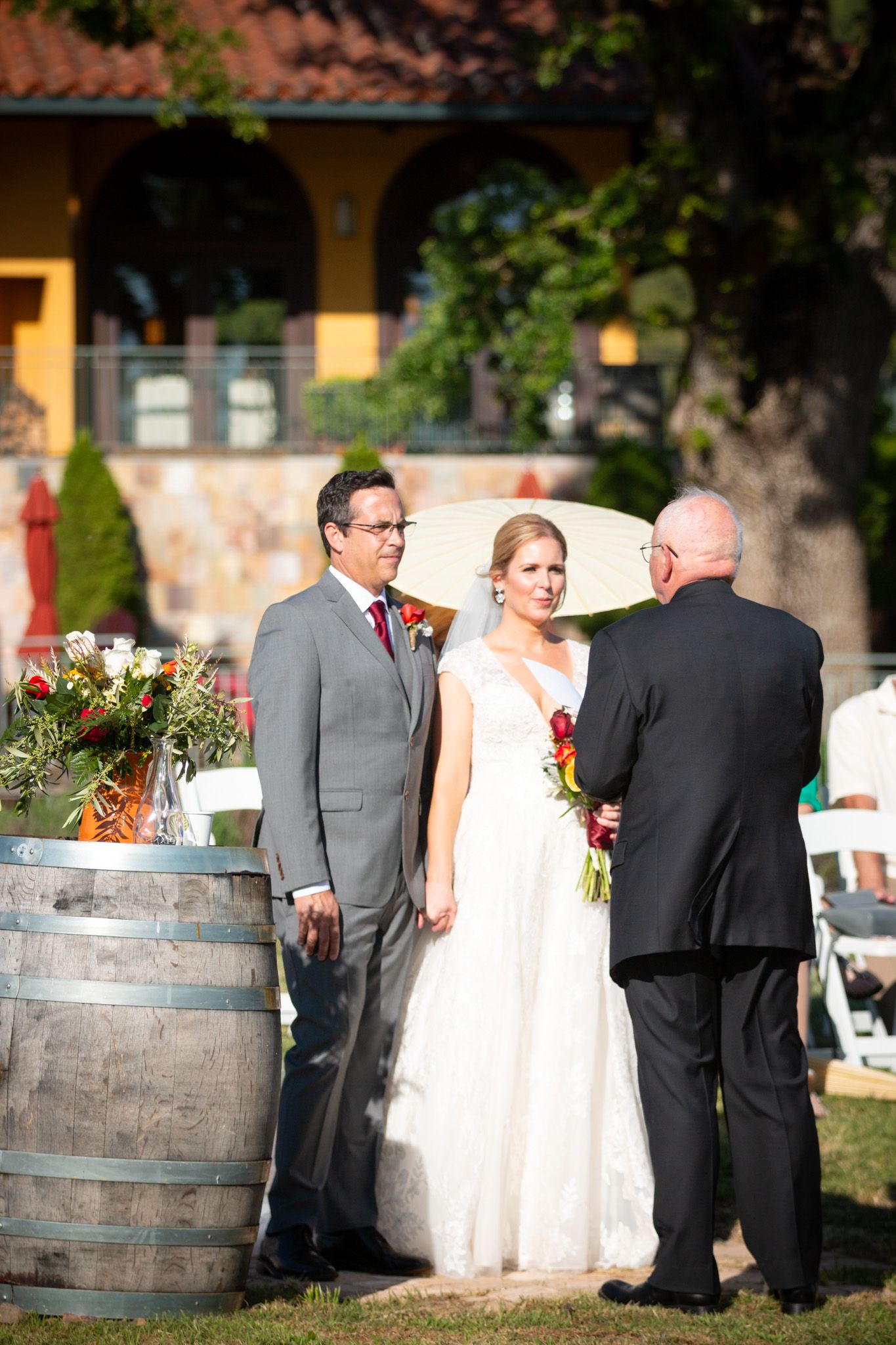 Intimate outdoor wedding moment at vineyard with mountains in background.