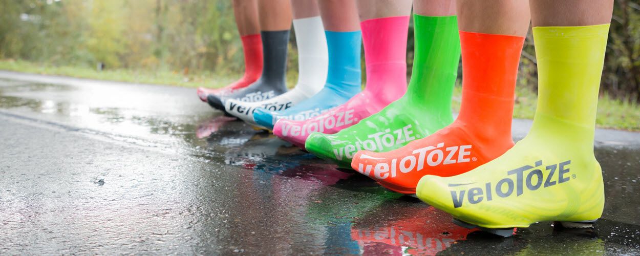 Colorful cycling socks and shoes lined up against a blurred background.