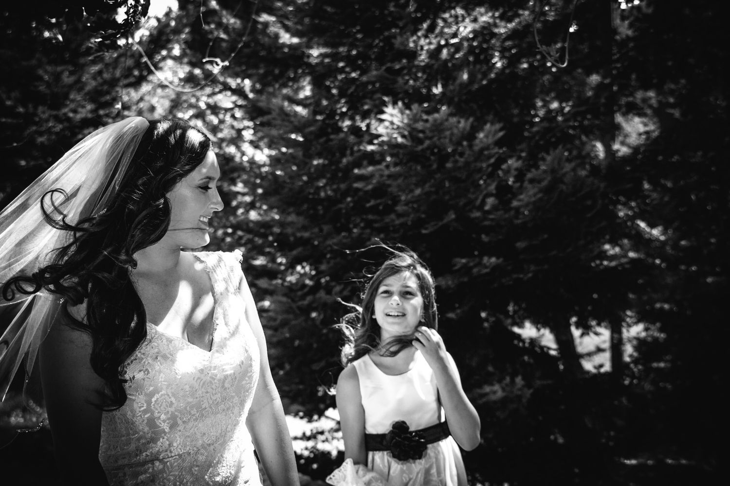 Black and white candid photo of wedding attendees in formal attire.