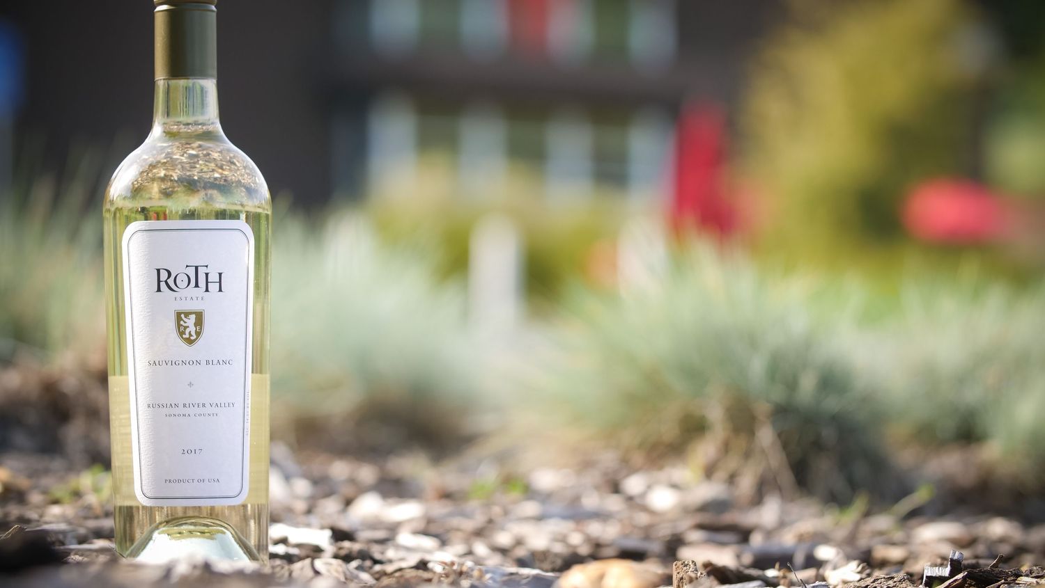 Bottle of white Roth wine photographed outdoors with shallow depth of field and natural background.