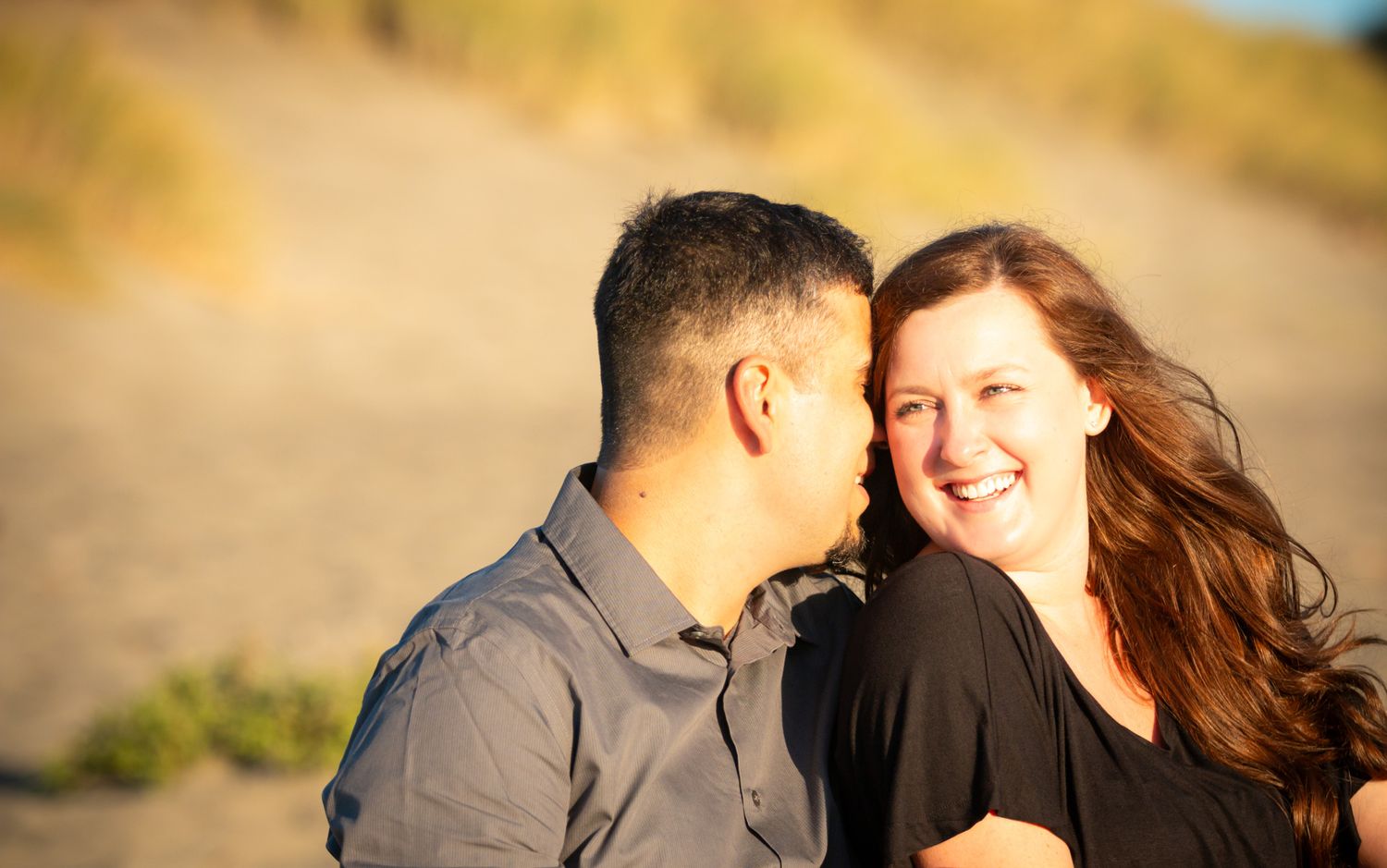 Couple sharing an intimate moment outdoors in warm sunlight.