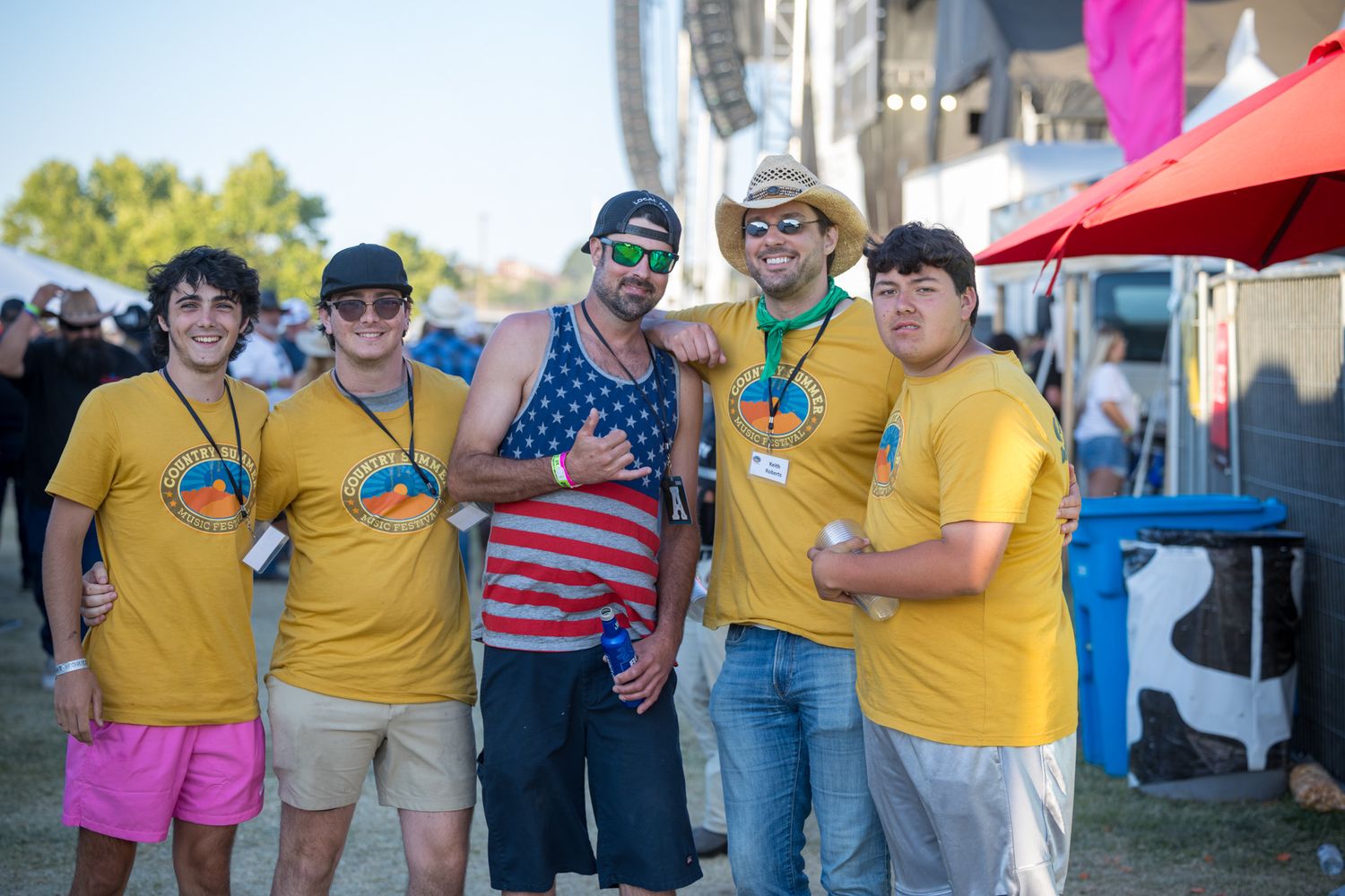 A collage of people wearing yellow shirts at an outdoor event with umbrellas and tents in the background.